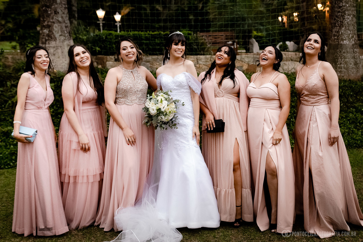 Foto da noiva vestida com vestido de noiva com as madrinhas vestidas com vestido rosa