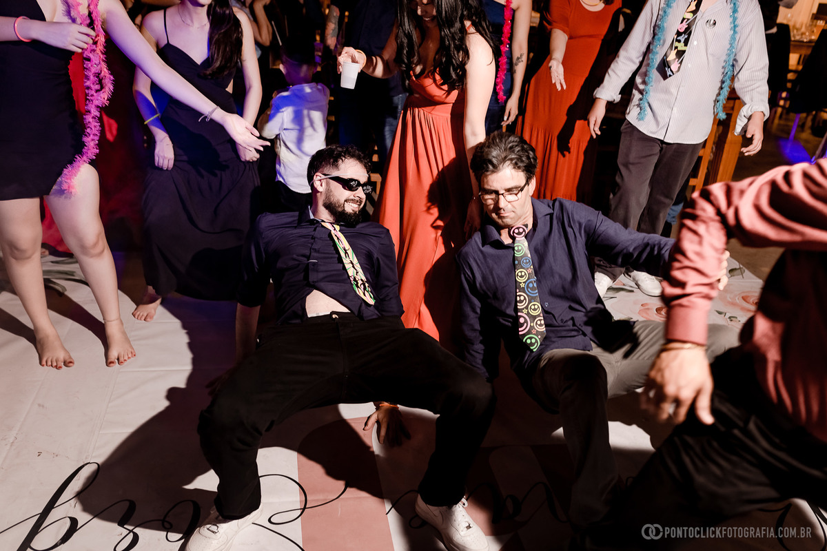Dois convidados dançando no chão na festa de casamento em Araçariguama