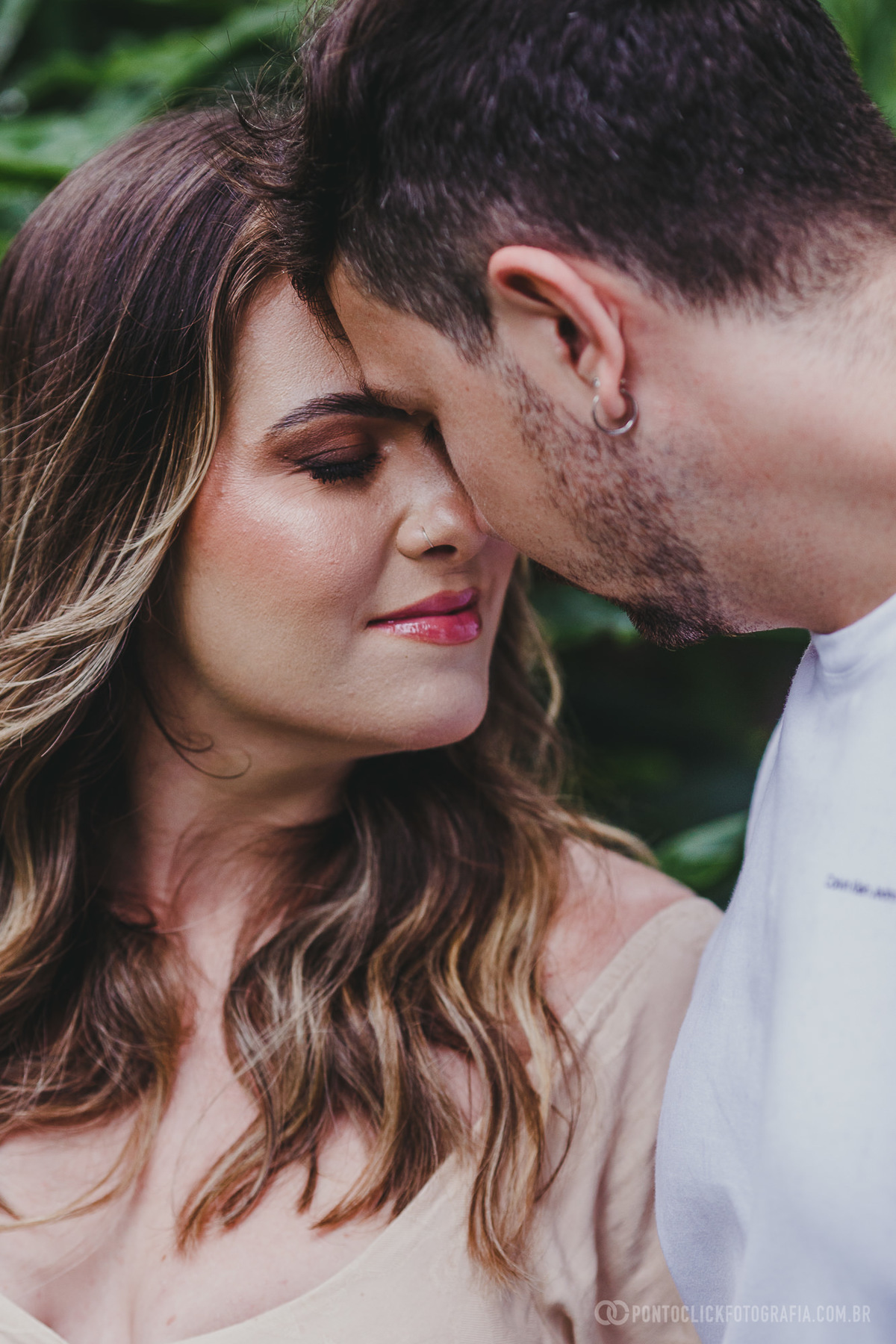 Close do casal com olhos fechados, compartilhando um momento íntimo e cheio de emoção. O foco nos detalhes é realça a delicadeza do momento.