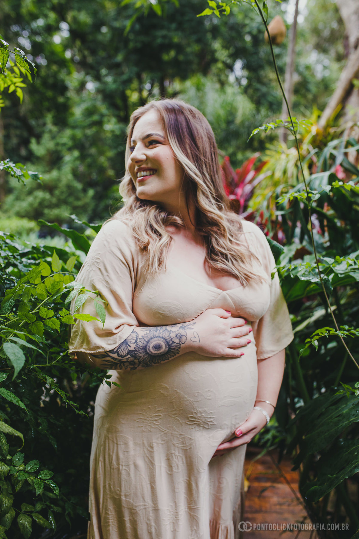 Fernanda sorri em meio à vegetação, proteção delicadamente a barriga. Um retrato que capta a felicidade e a serenidade da futura mamãe durante o ensaio