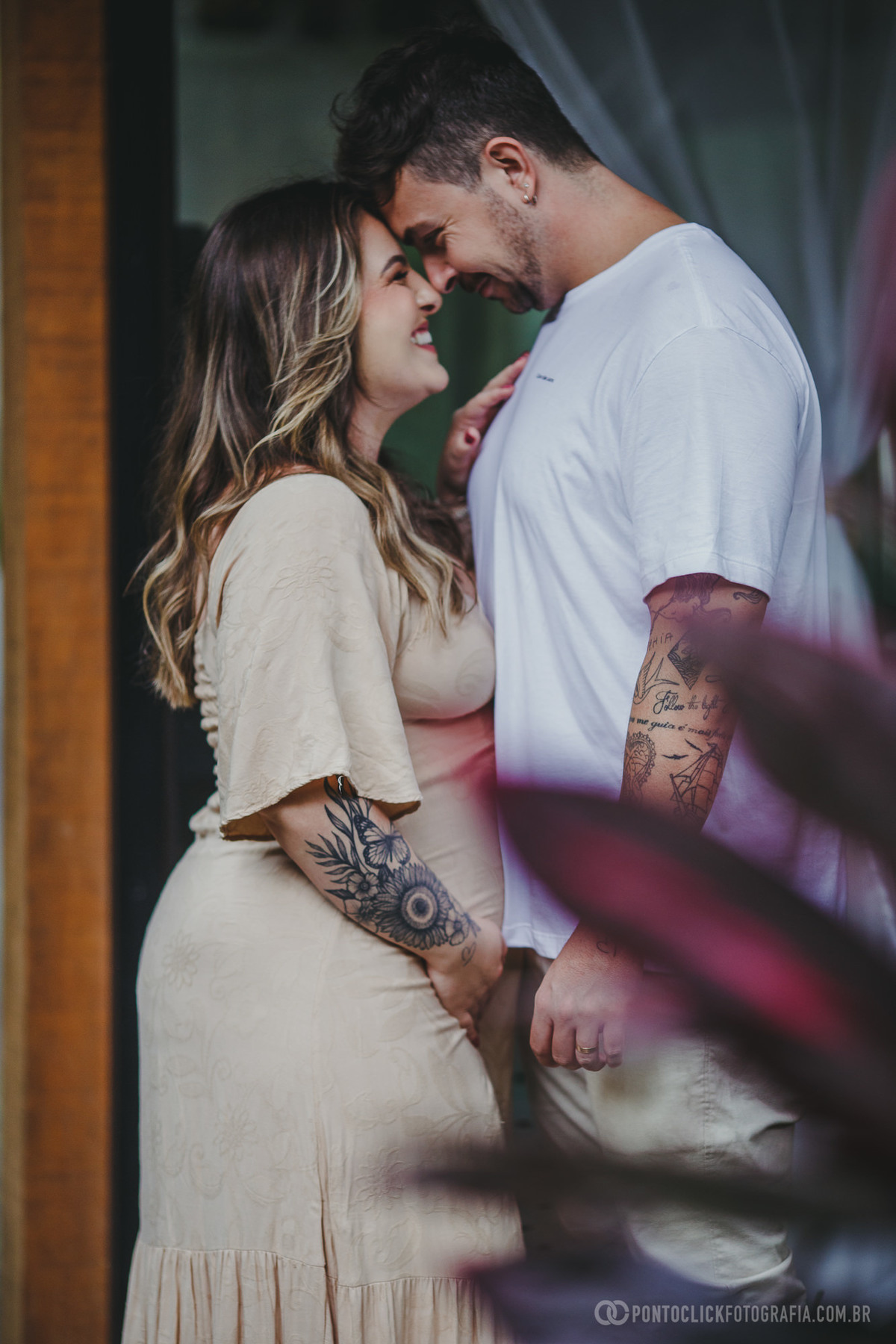 O casal se aproxima em um gesto de carinho, com testas encostadas. Um momento íntimo e cheio de ternura, eternizado em meio ao ambiente natural.