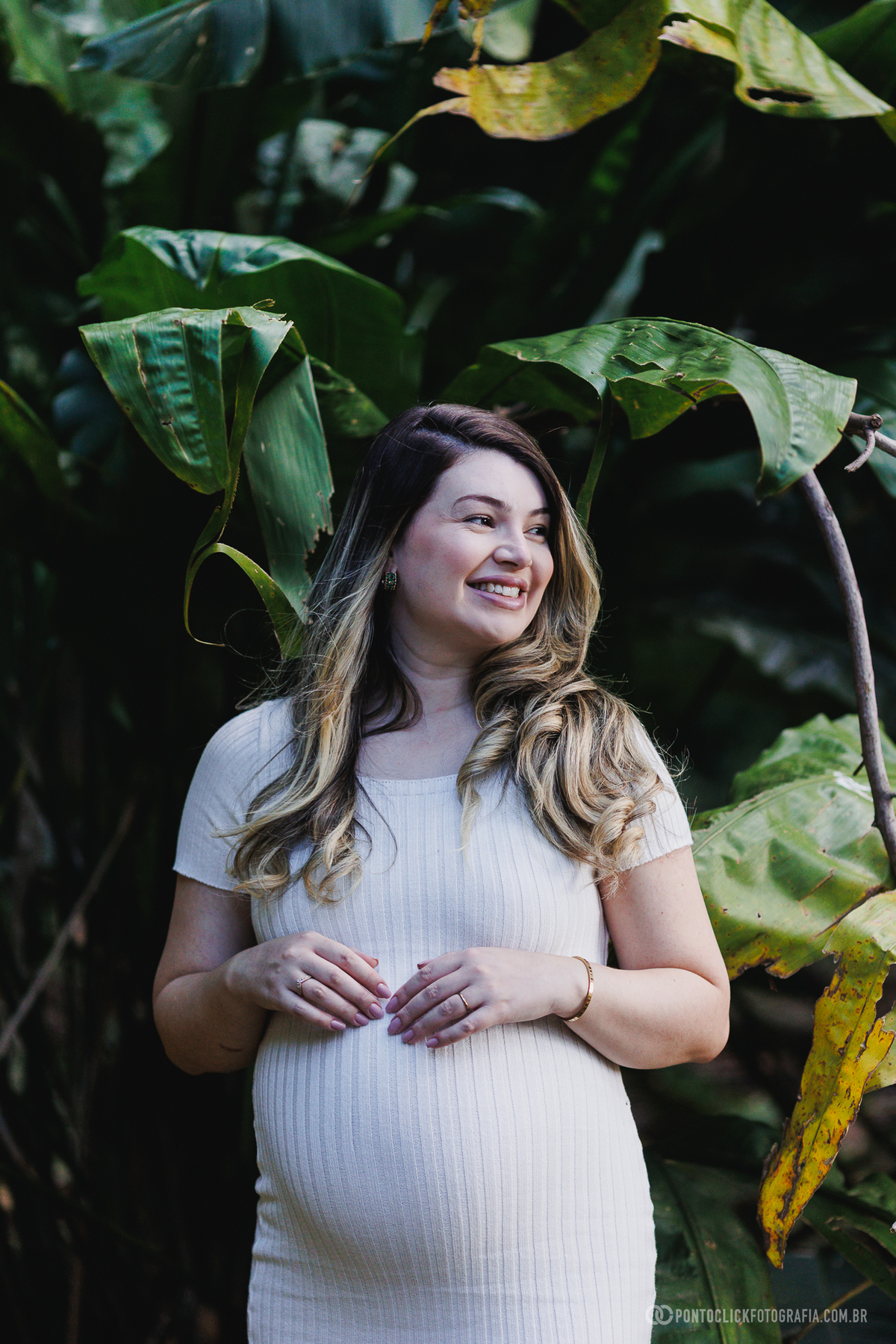 ensaio gestante em meio à natureza com folhas e luz natural criando atmosfera leve e valorizando a beleza da maternidade