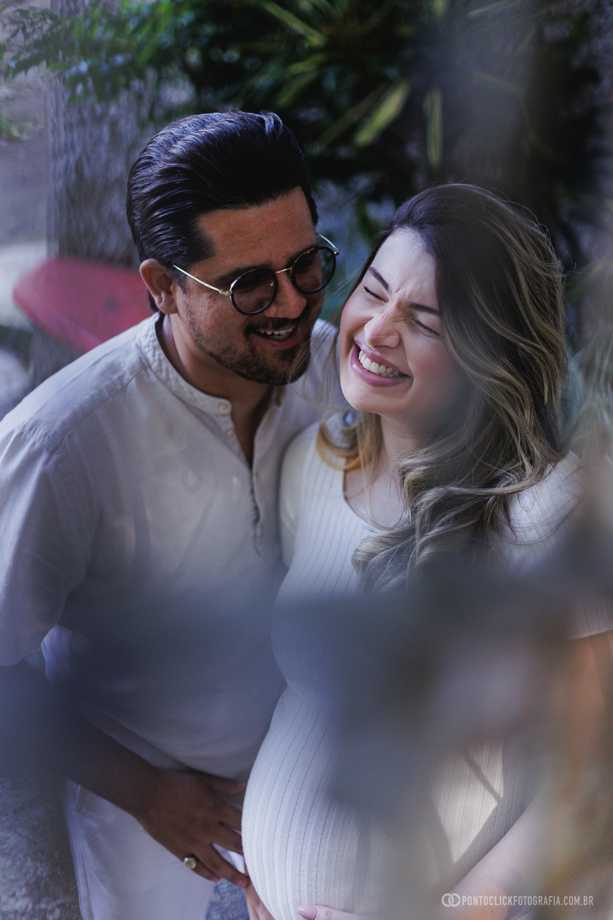 ensaio gestante em família em São Roque com luz natural entre árvores destacando a conexão e a espera do bebê John com fotografia suave e emocional ao ar livre