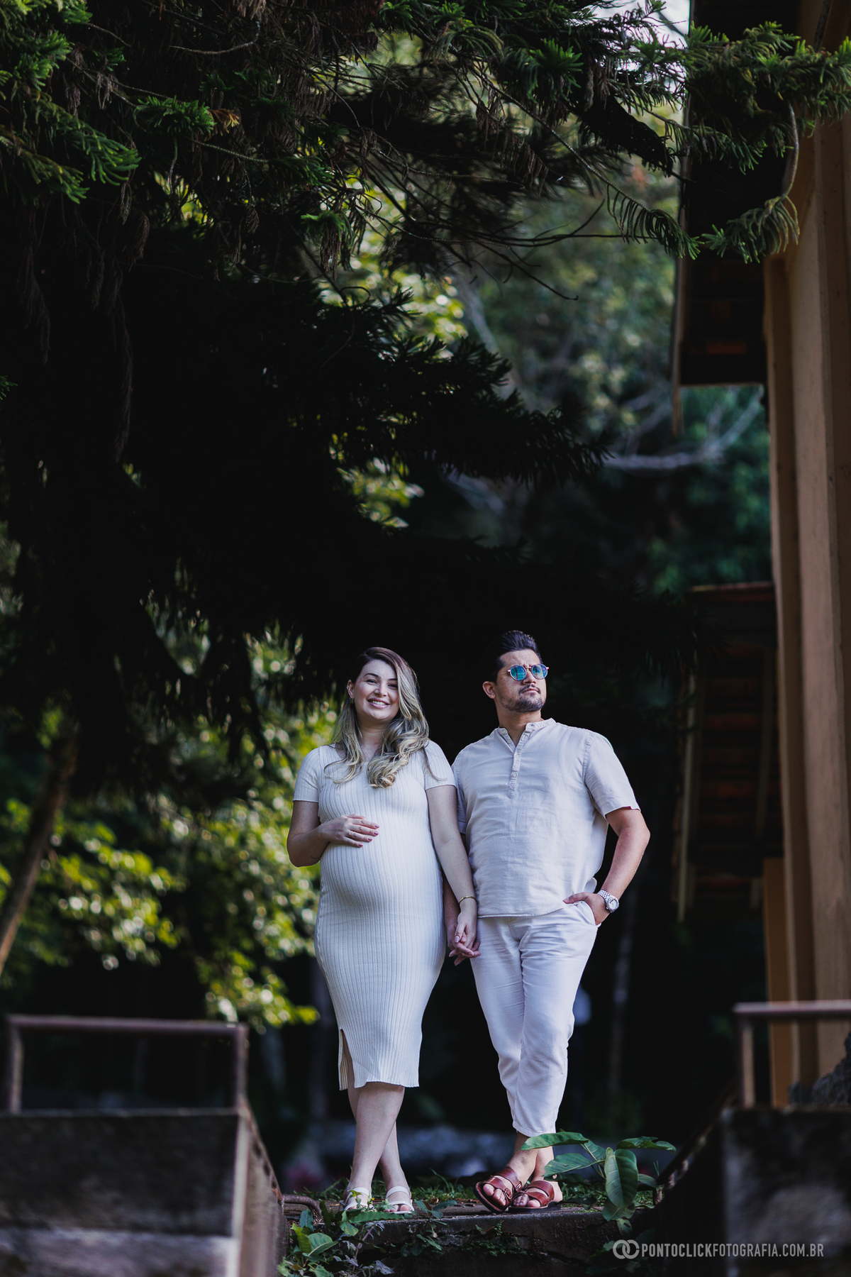 fotos de gestante casal caminhando juntos em ambiente externo com composição ampla valorizando conexão, movimento e natureza