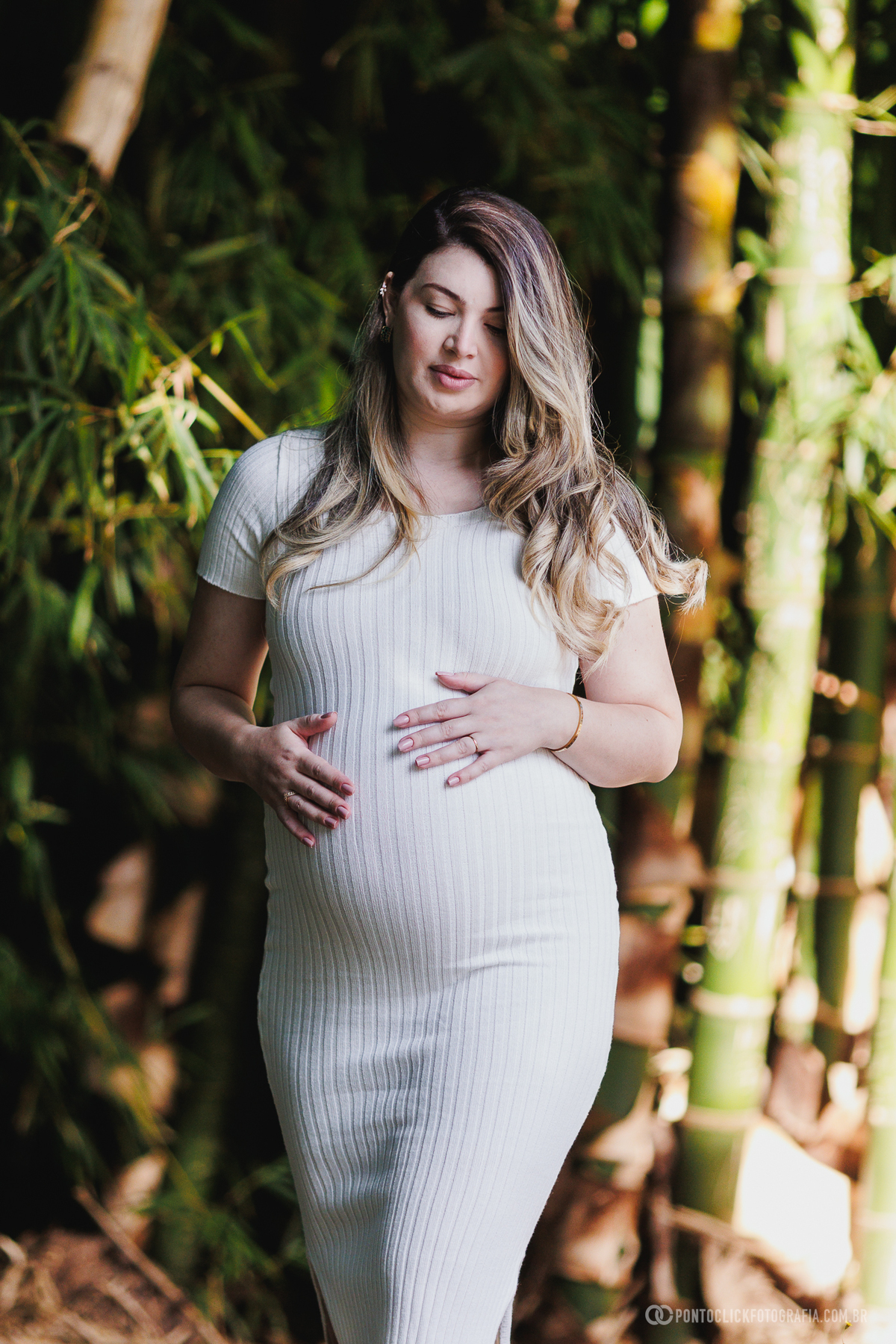 ensaio gestante em família em São Roque com luz natural entre árvores destacando a conexão e a espera do bebê John com fotografia suave e emocional ao ar livre