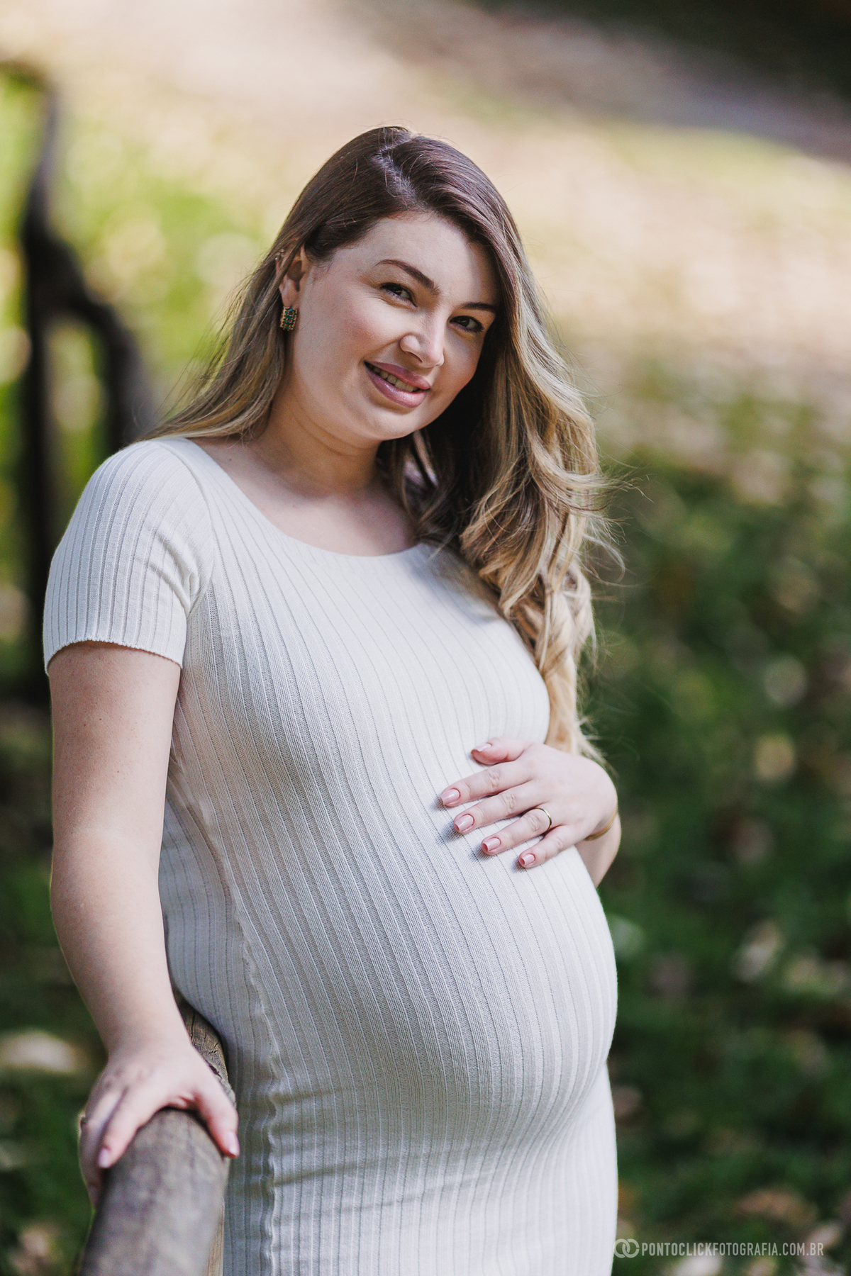 ensaio gestante em família em São Roque com luz natural entre árvores destacando a conexão e a espera do bebê John com fotografia suave e emocional ao ar livre