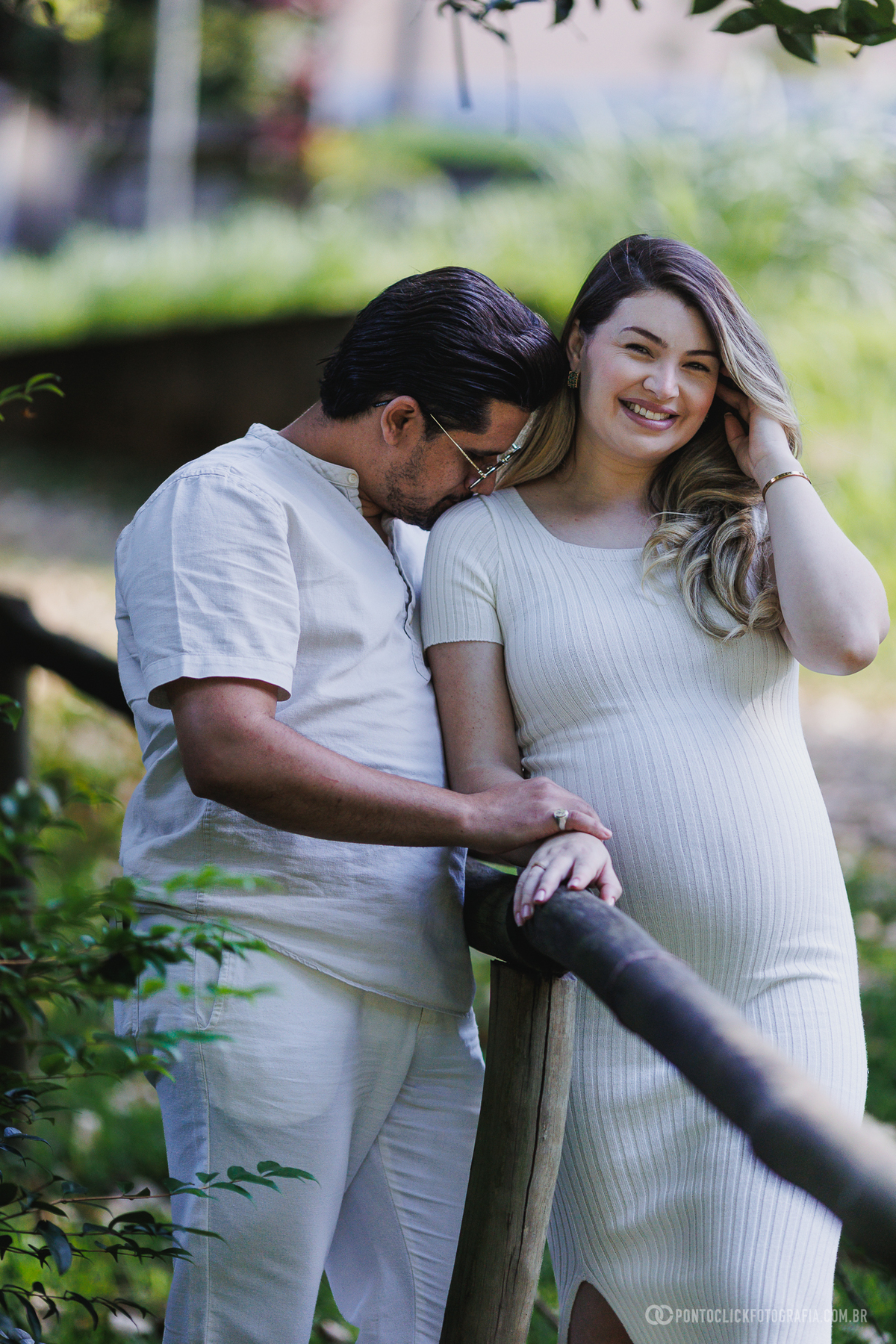 ensaio gestante em família em São Roque com luz natural entre árvores destacando a conexão e a espera do bebê John com fotografia suave e emocional ao ar livre