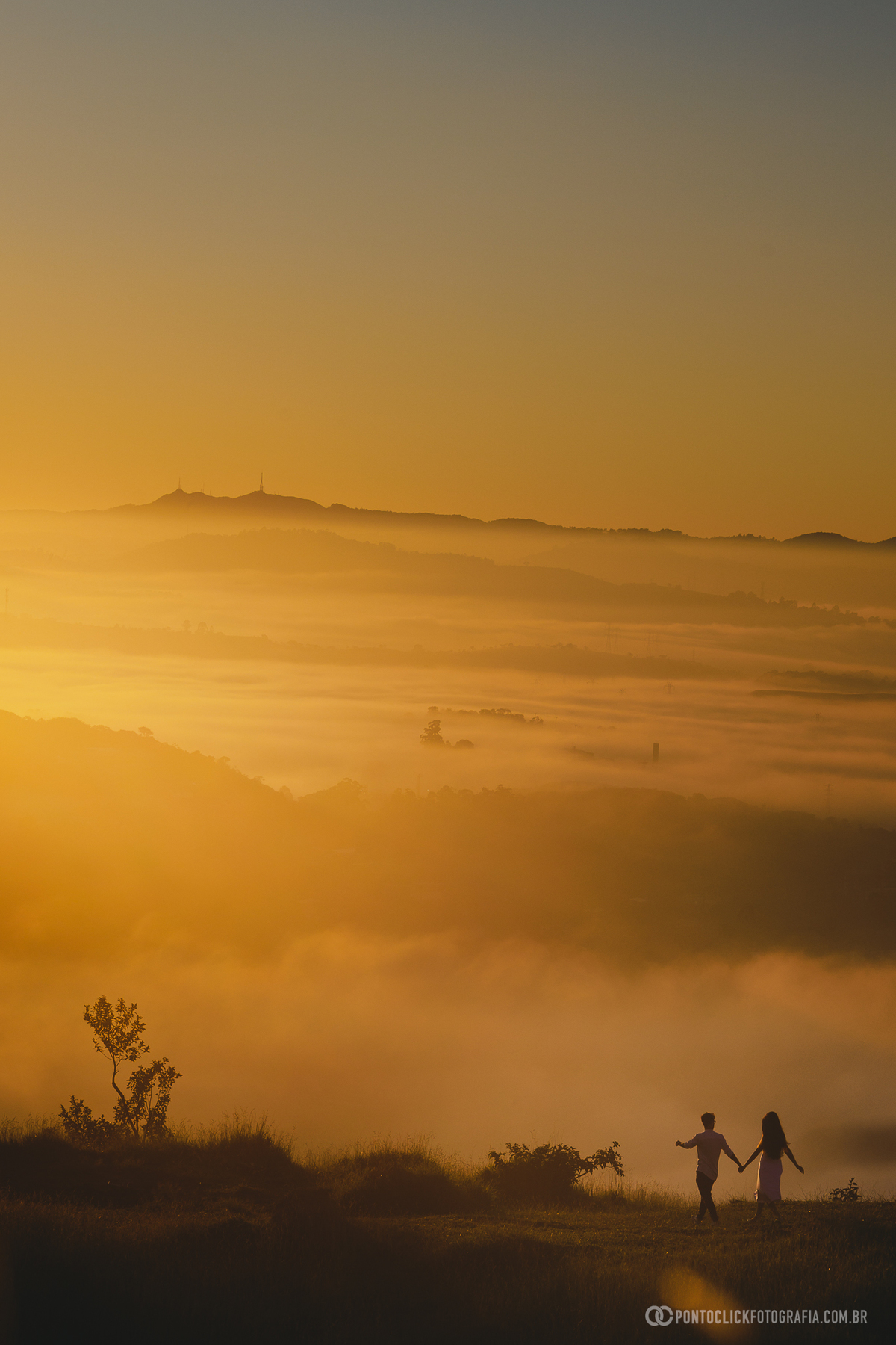 Paisagem no Morro do Capuava em Pirapora do Bom Jesus ao nascer do sol com mar de nuvens iluminado por luz dourada criando cenário amplo e natural com montanhas ao fundo e atmosfera cinematográfica