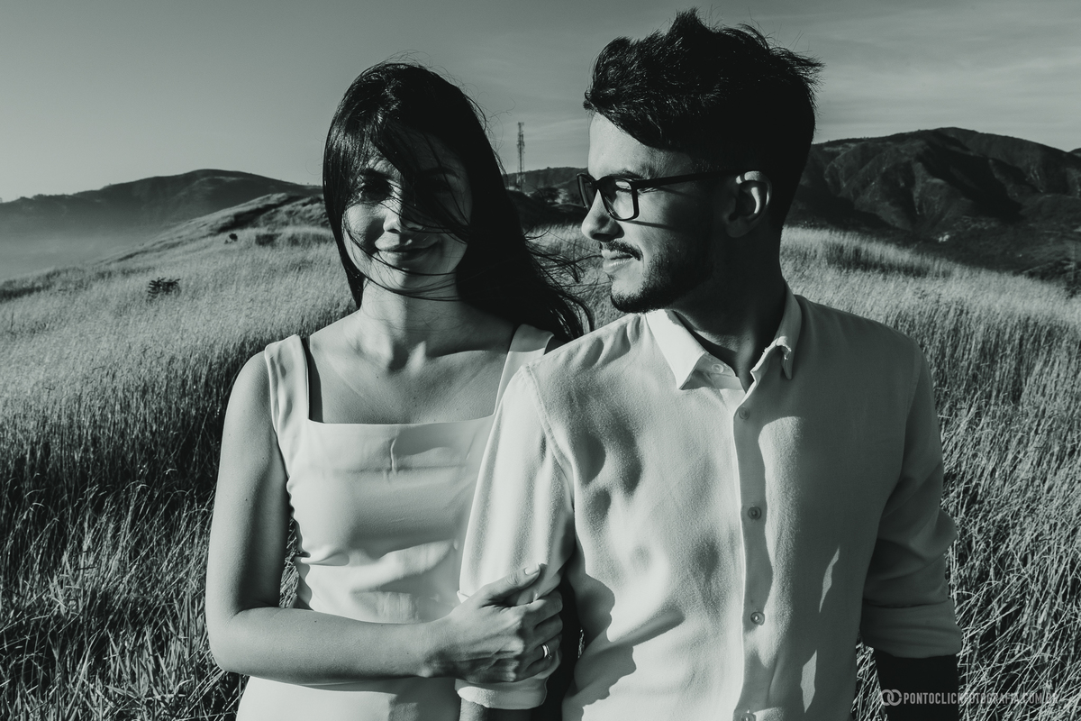 Casal em ensaio pré wedding no Morro do Capuava em Pirapora do Bom Jesus em retrato preto e branco com vegetação ao redor destacando expressão e conexão em cenário natural