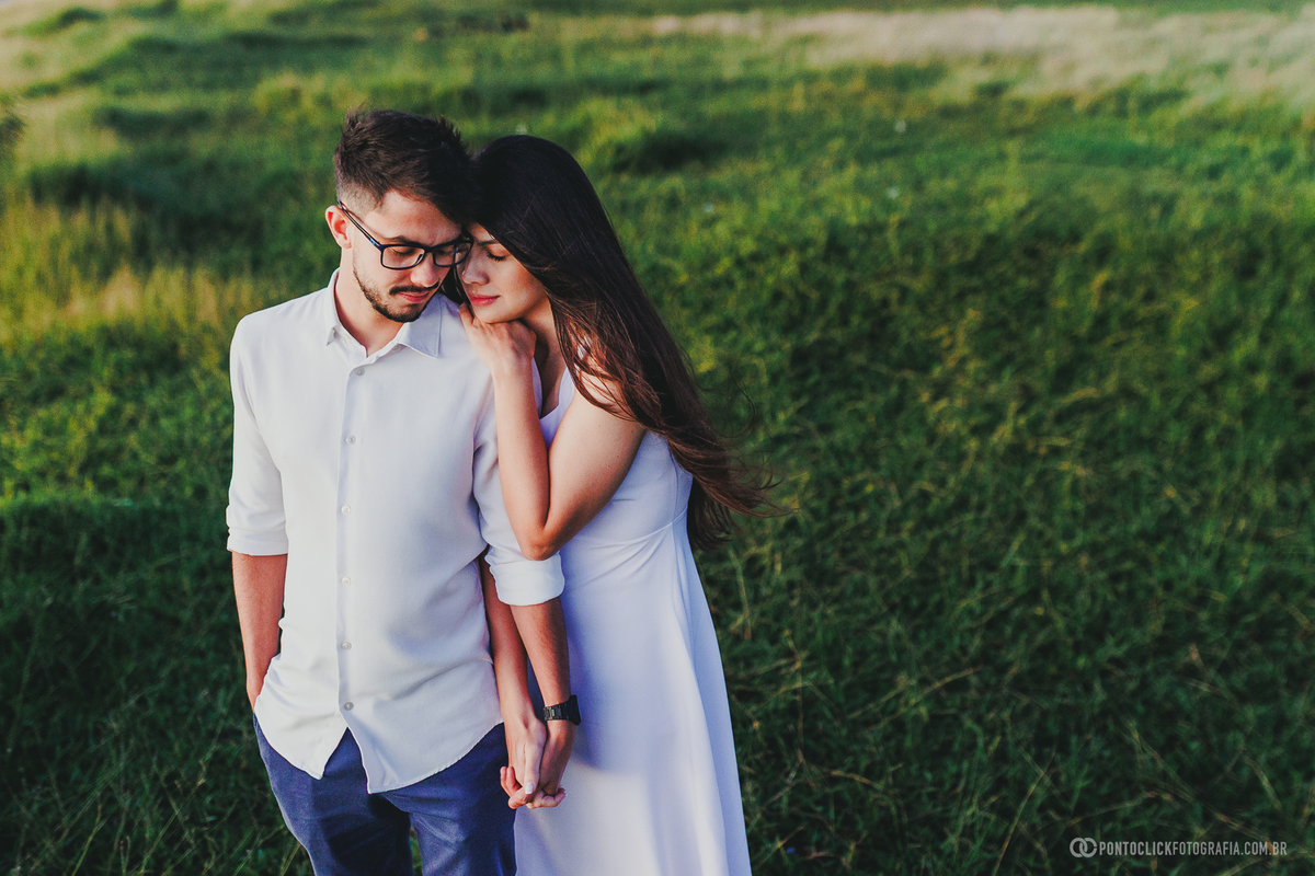 Casal em ensaio pré wedding no Morro do Capuava em Pirapora do Bom Jesus com enquadramento superior, demonstrando conexão e proximidade em meio à vegetação com iluminação natural suave do amanhecer