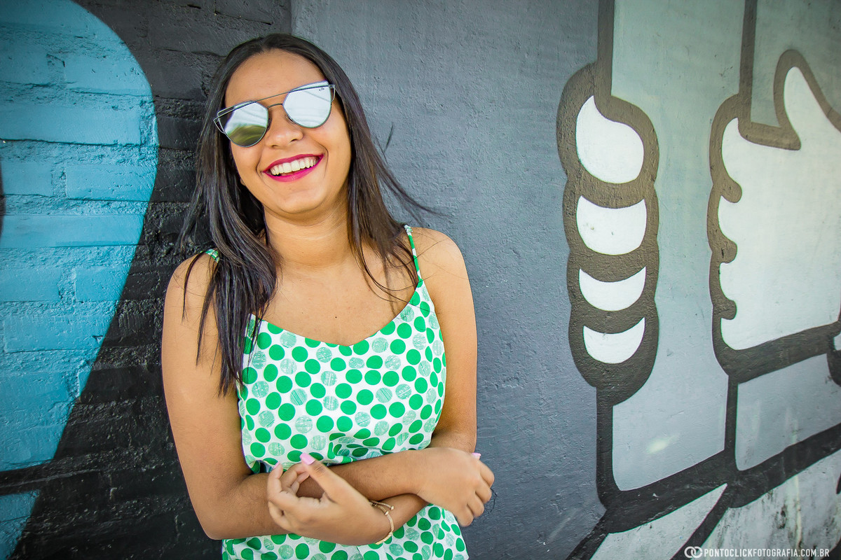 sorrindo segurando os braços no beco do batman