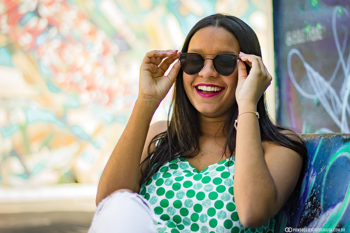 Segurando oculos e sentada na rua do beco do batmam