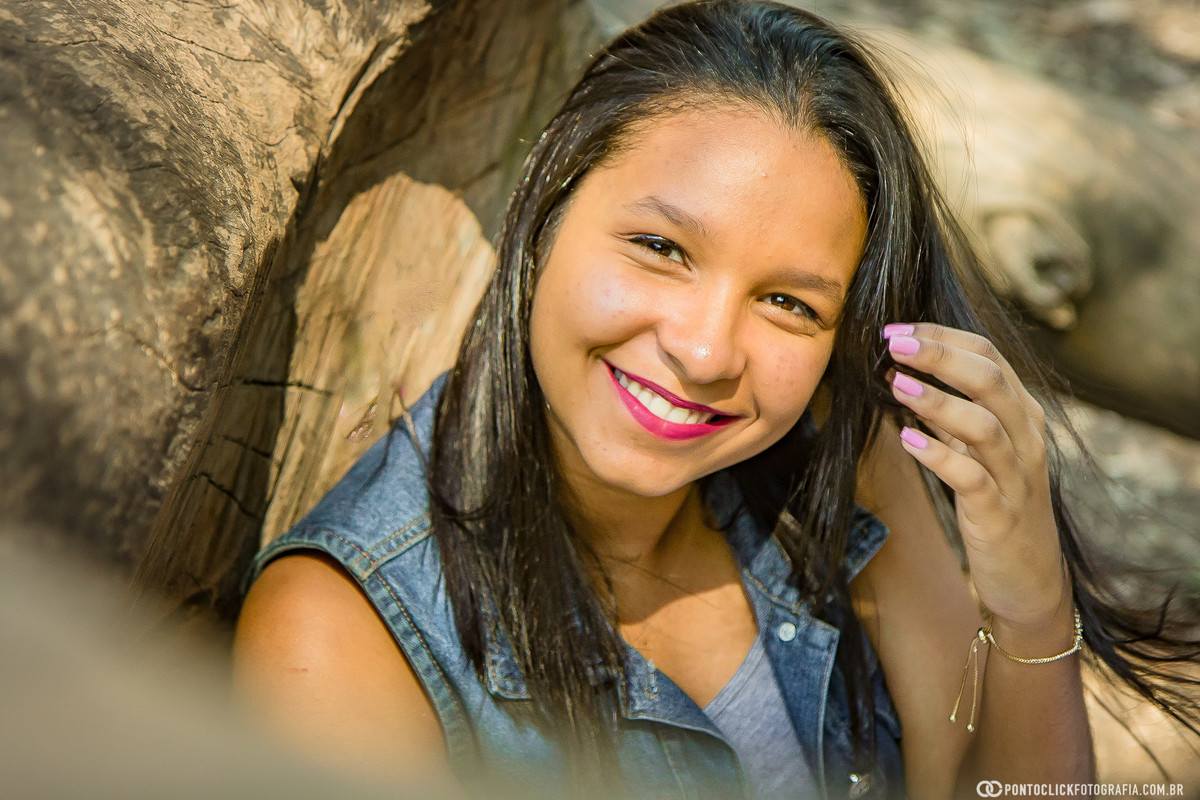 sorrindo e sentada num tronco do parque ibirapuera