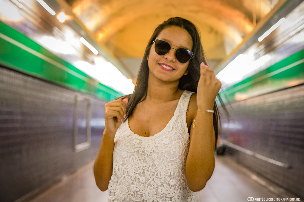 sorrindo com a mao no cabelo no metro da avenida paulista