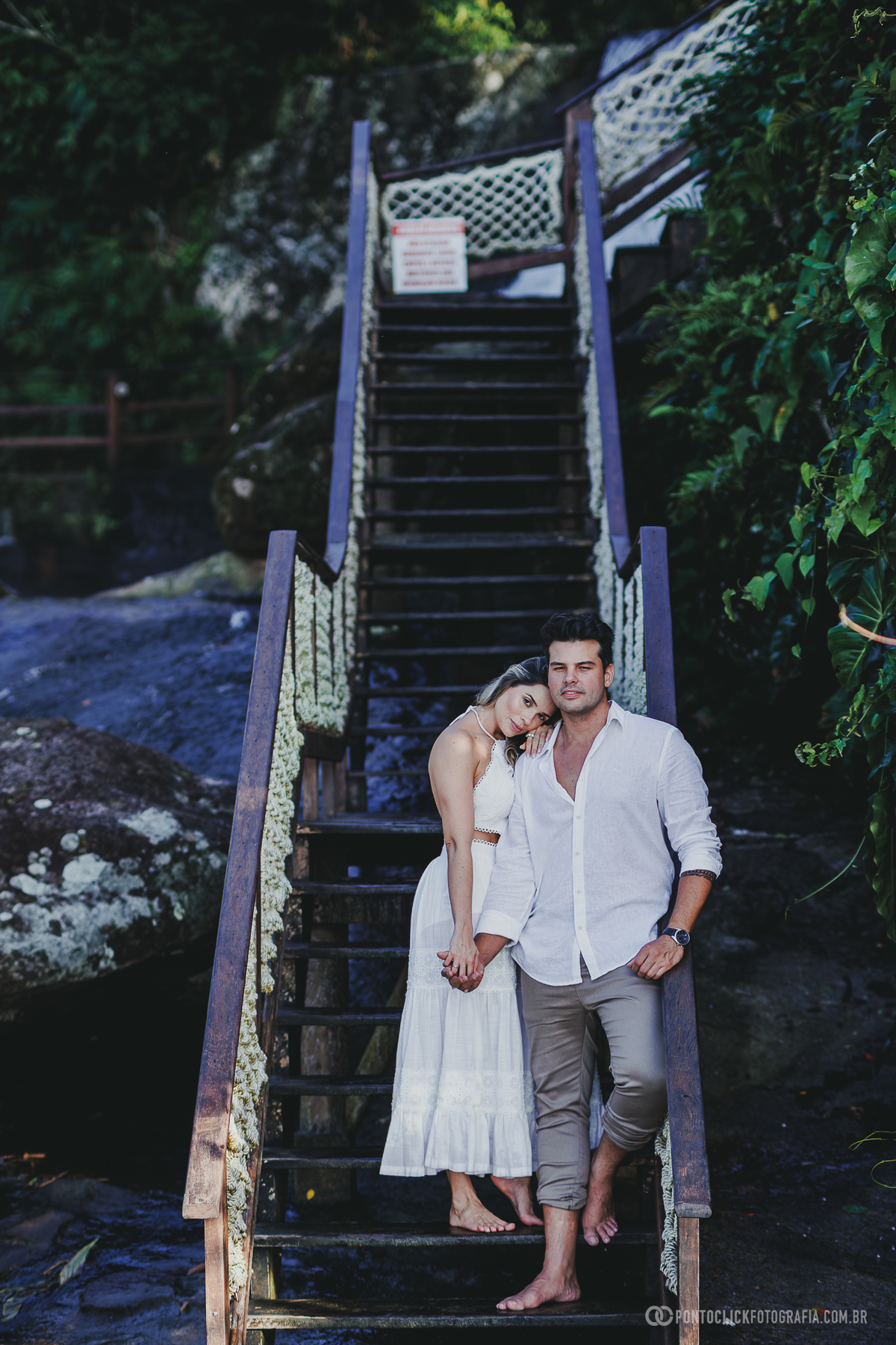 Fotografia pre wedding de Guilherme e Katioska caminhando pela praia do Guarujá ao entardecer, com reflexos na areia molhada e cenário natural valorizando o romantismo do casal.