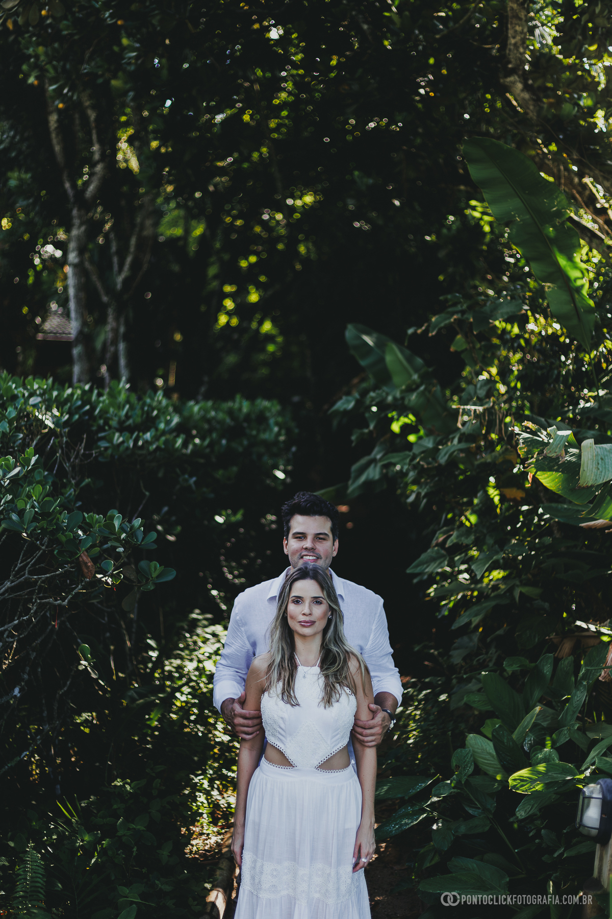 Fotografia de casal realizada no Guarujá com Guilherme e Katioska em cenário tropical cercado pela natureza, destacando composição elegante, luz natural e conexão do casal durante ensaio pré wedding