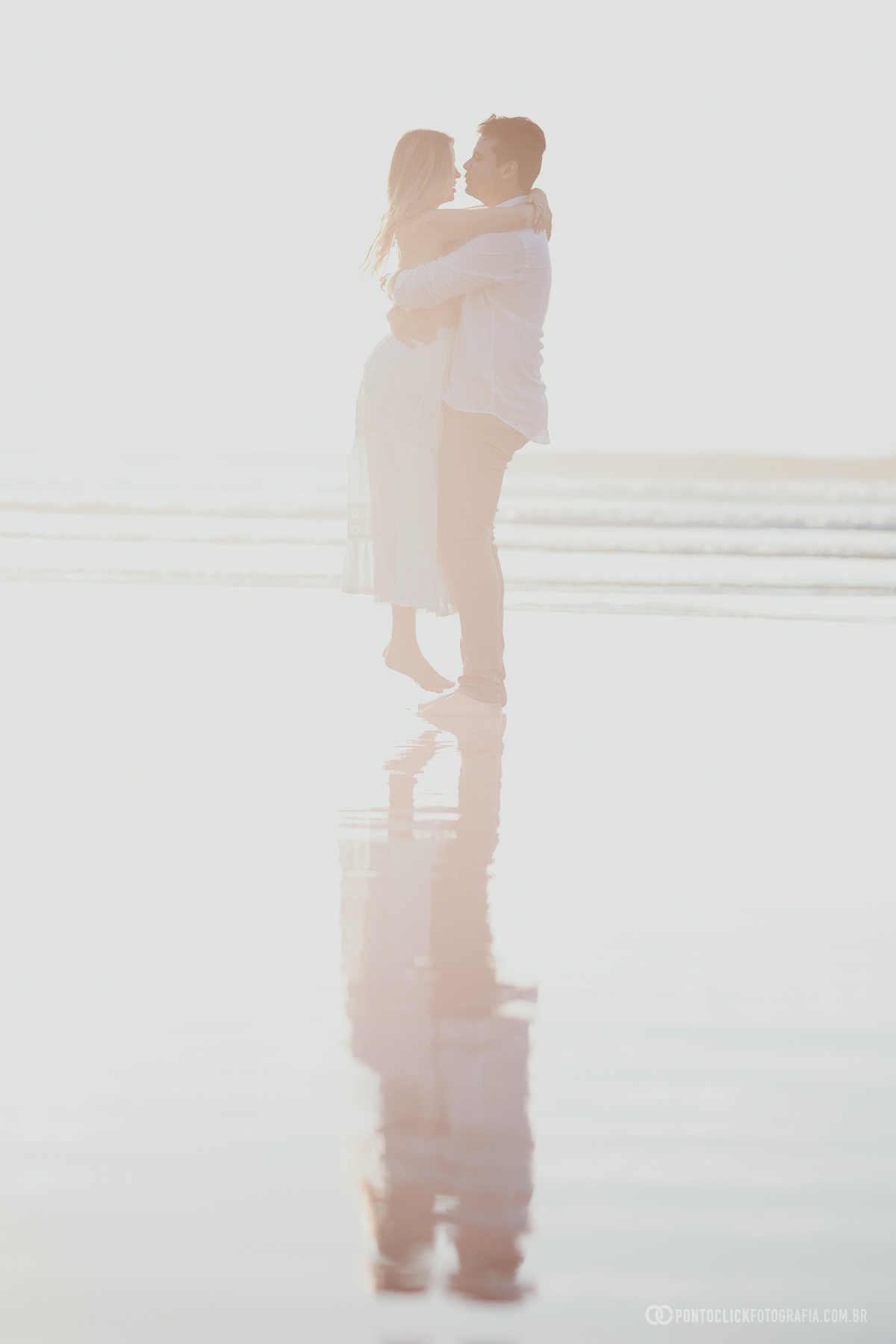 Fotografia pré wedding de Guilherme e Katioska realizada no Guarujá durante o pôr do sol na praia, captando movimento, romantismo e conexão do casal em cenário leve e natural à beira-mar
