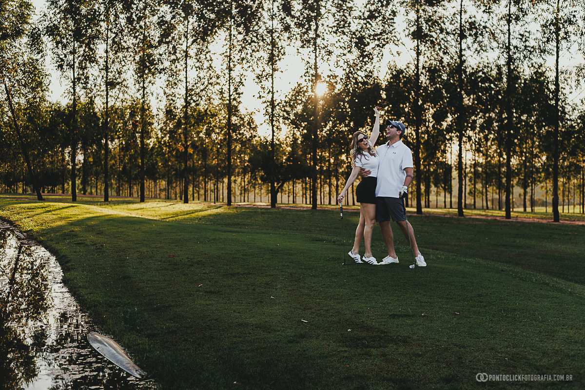 Casal celebra momentos especiais durante ensaio fotográfico lifestyle em campo de golfe. A composição destaca alegria, descontração e a beleza do cenário natural, ideal para registrar histórias de forma espontânea