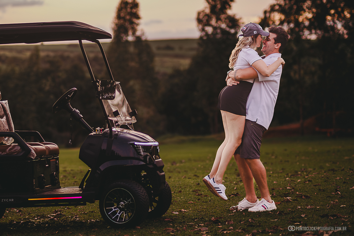 Casal celebra o momento com um abraço durante ensaio fotográfico em campo de golfe. A composição une romantismo, natureza e um cenário sofisticado para criar imagens espontâneas e marcantes ao ar livre