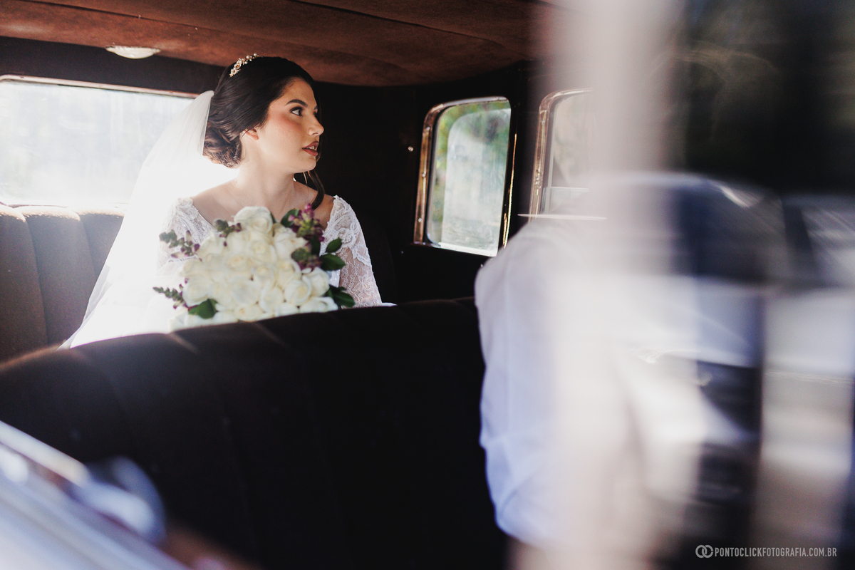 Durante o trajeto até a cerimônia, a noiva segura o buquê e contempla o caminho com serenidade, registrando a emoção dos minutos que antecedem o casamento. Fotógrafo de casamento Pontoclick Fotografia