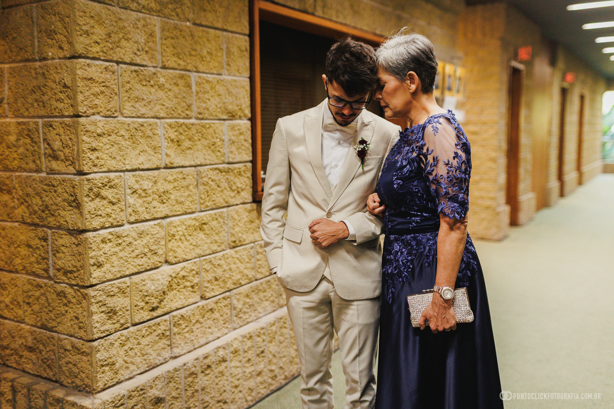 O noivo compartilha um momento de oração e apoio ao lado de sua mãe antes da cerimônia de casamento, em um registro cheio de significado e emoção. Fotógrafo de casamento Pontoclick Fotografia.