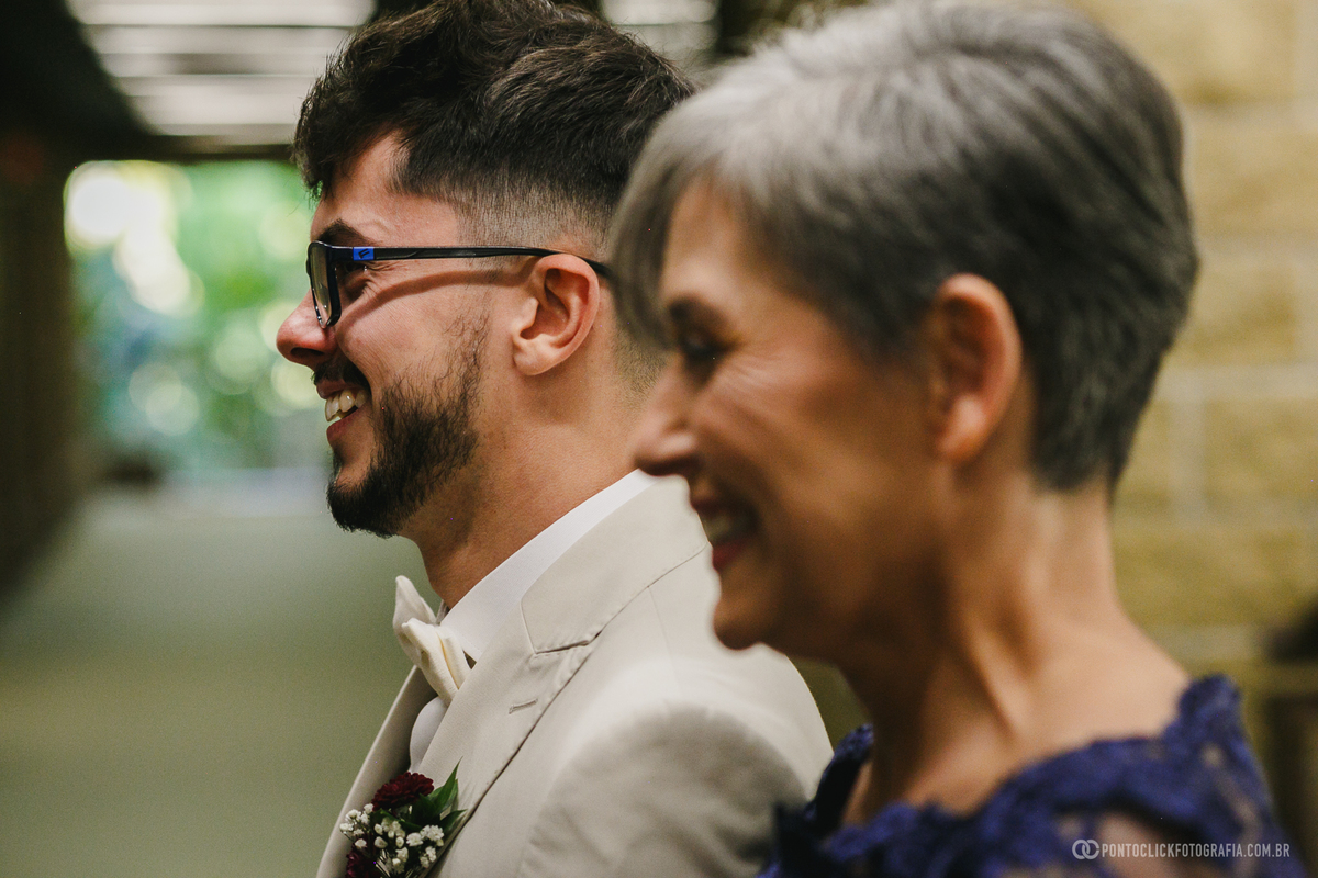 Sorrisos e emoção marcam a espera do noivo ao lado de sua mãe momentos antes do início da cerimônia de casamento. Fotógrafo de casamento Pontoclick Fotografia.