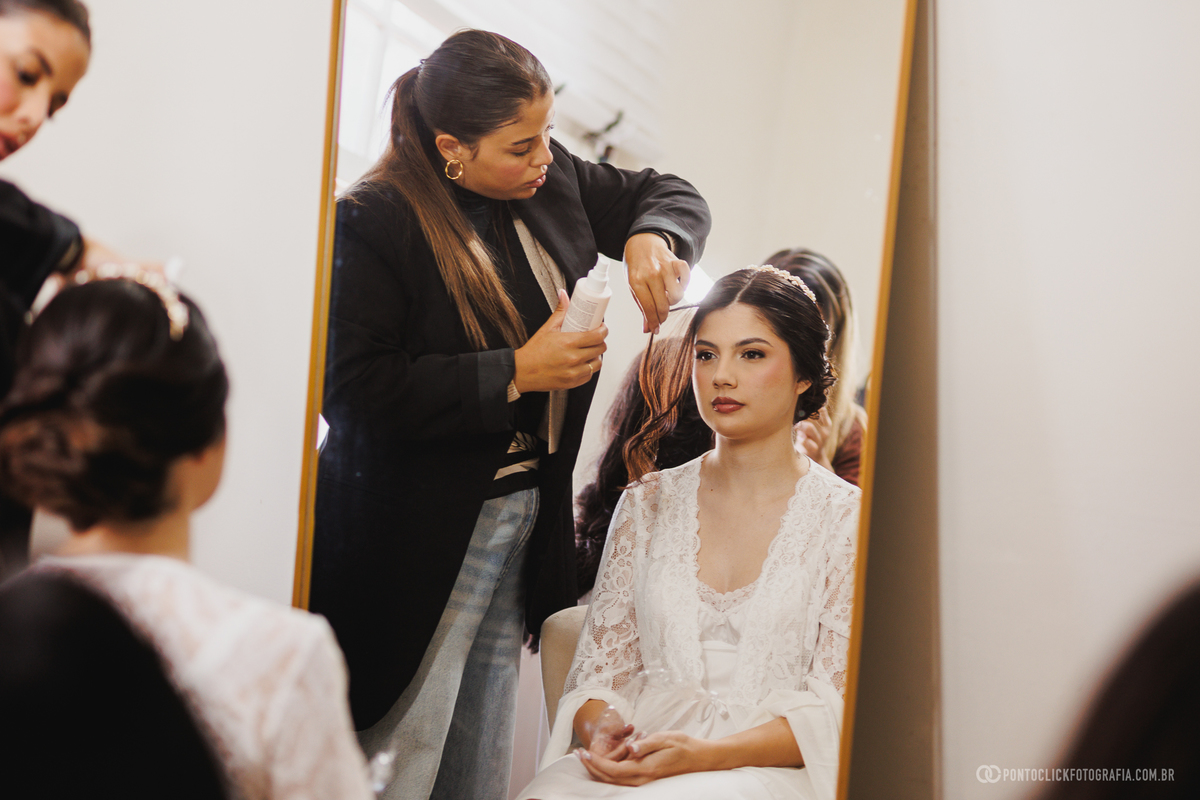 Os detalhes finais do penteado da noiva são realizados com delicadeza no making of do casamento. Registros que eternizam toda a preparação para a cerimônia. Fotógrafo de casamento Pontoclick Fotografia