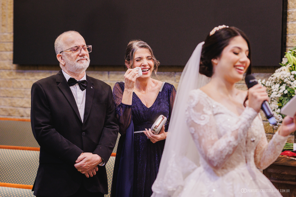 O sorriso espontâneo de uma convidada durante a cerimônia demonstra a alegria e a emoção presentes na celebração do casamento. Fotógrafo de casamento Pontoclick Fotografia.