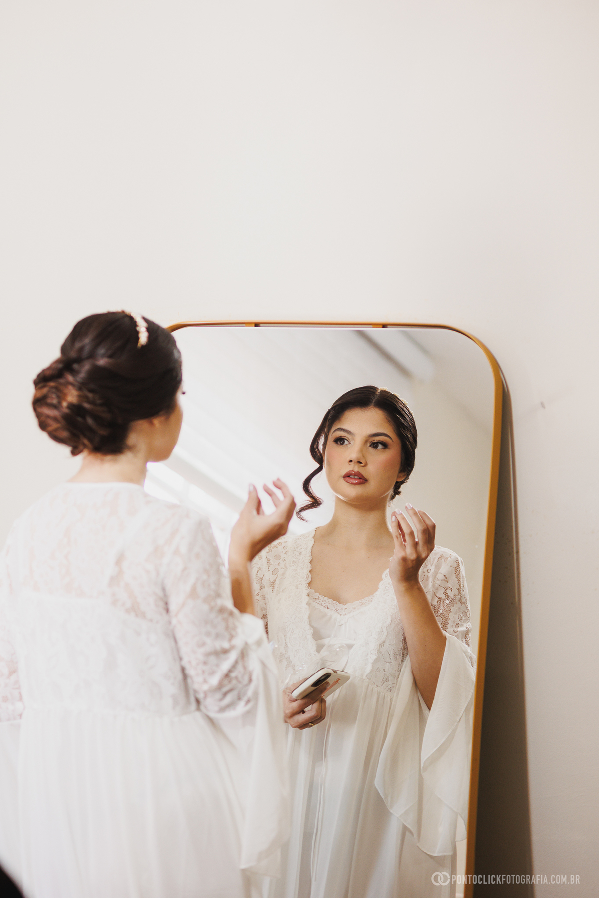 A noiva observa seu reflexo enquanto confere maquiagem e penteado momentos antes da cerimônia. Um instante de expectativa registrado de forma leve e natural. Fotógrafo de casamento Pontoclick Fotografia