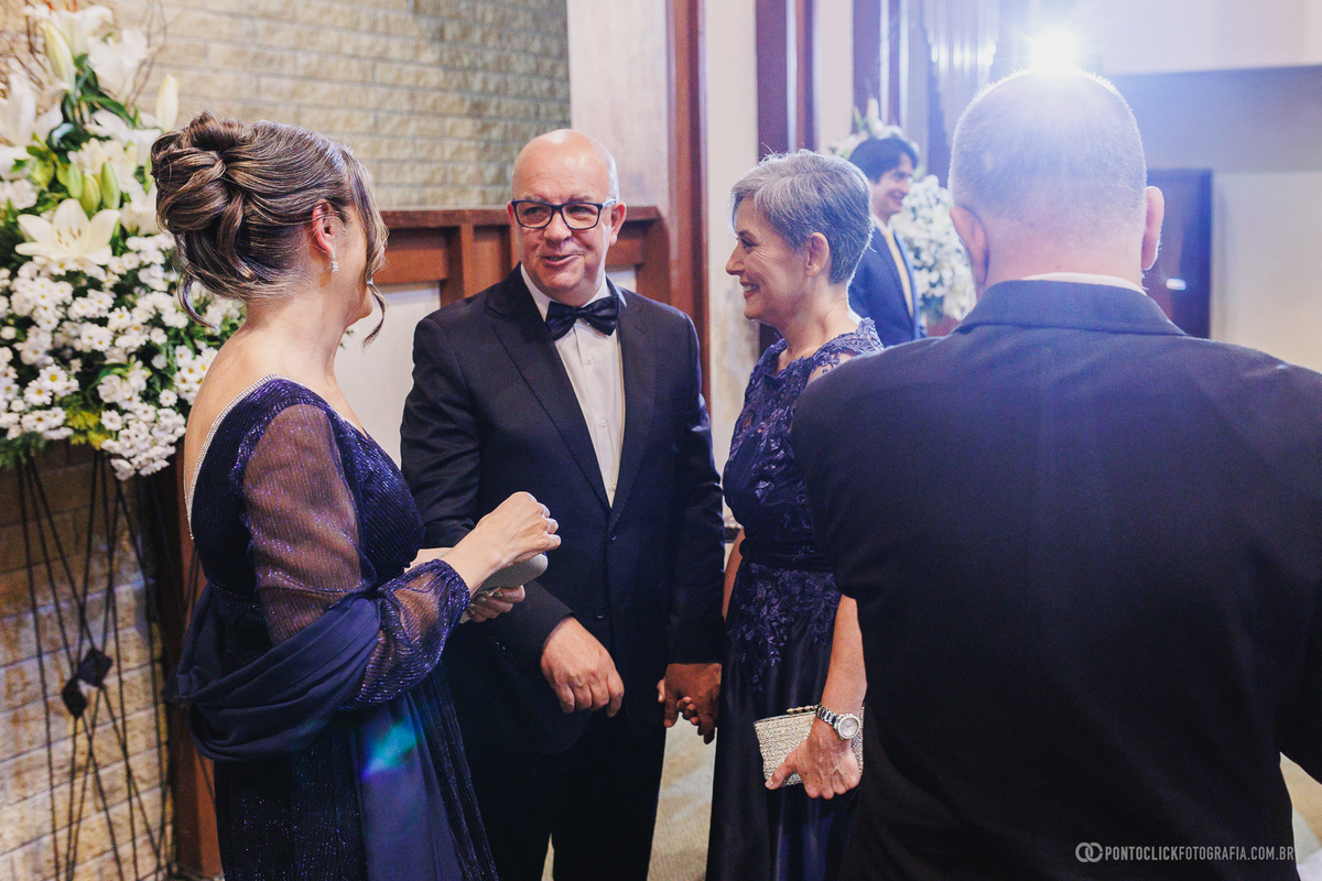 Pais e familiares conversam antes do encerramento da cerimônia, registrando encontros e momentos espontâneos durante a celebração do casamento. Fotógrafo de casamento Pontoclick Fotografia.