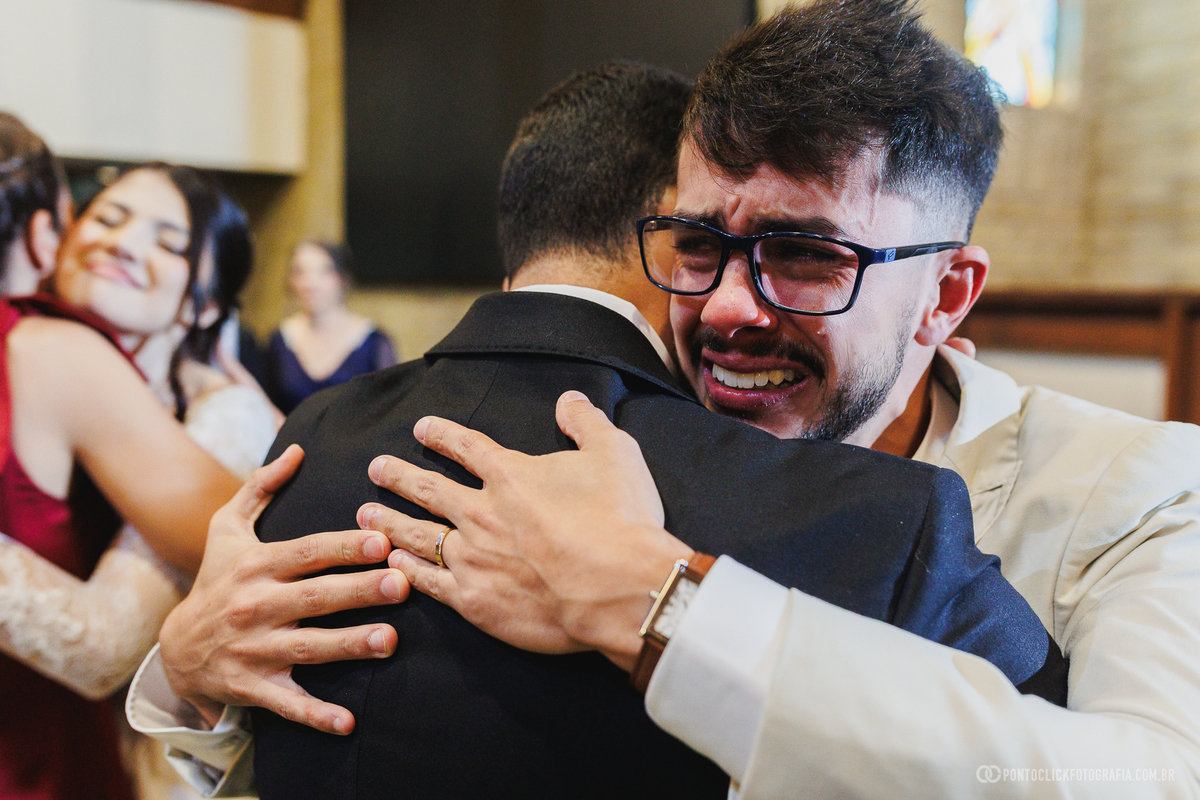 O noivo se emociona profundamente ao receber um abraço de um familiar após a cerimônia, eternizando um instante repleto de sentimento e gratidão. Fotógrafo de casamento Pontoclick Fotografia.