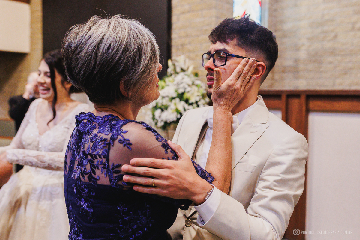 O noivo recebe o carinho de um familiar logo após a cerimônia, vivendo um momento emocionante que ficará marcado na memória da família. Fotógrafo de casamento Pontoclick Fotografia.