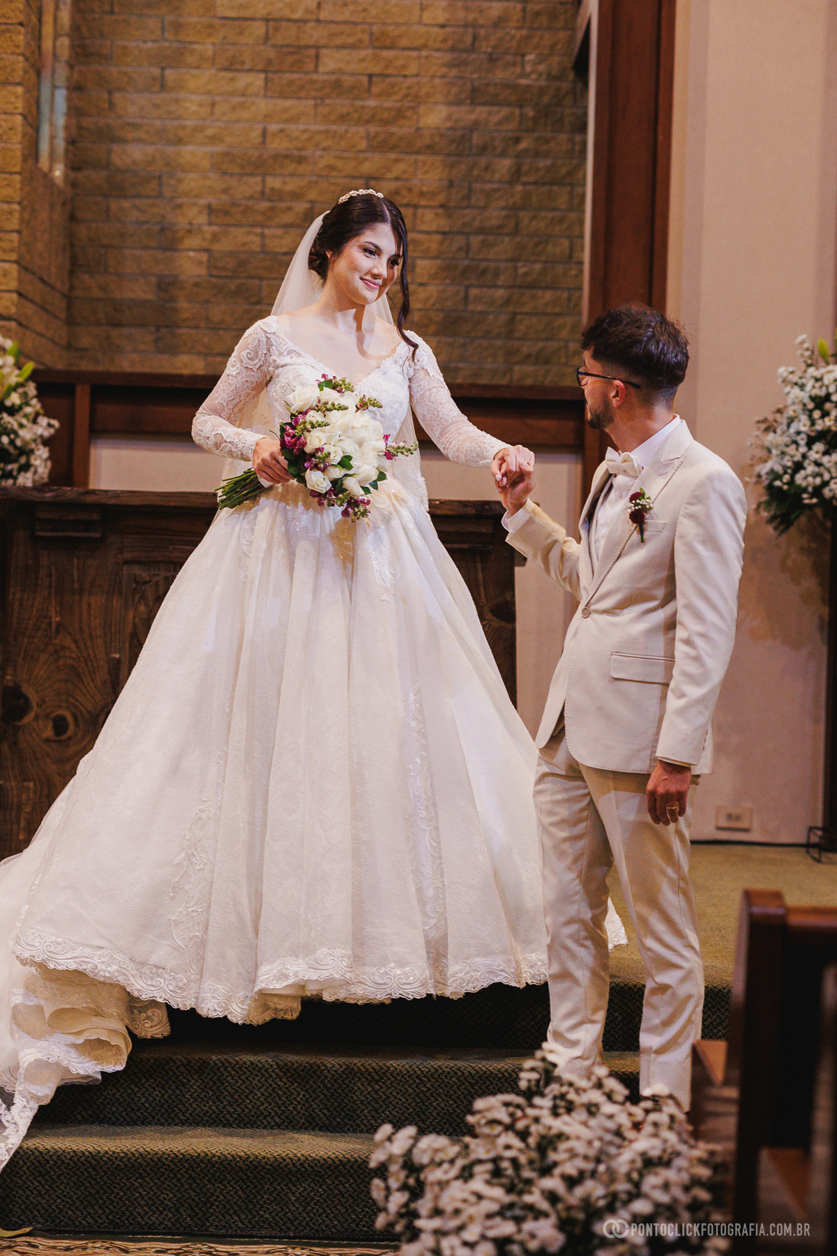 O noivo conduz a noiva pelos degraus do altar em um momento delicado e cheio de carinho logo após a cerimônia de casamento. Fotógrafo de casamento Pontoclick Fotografia.