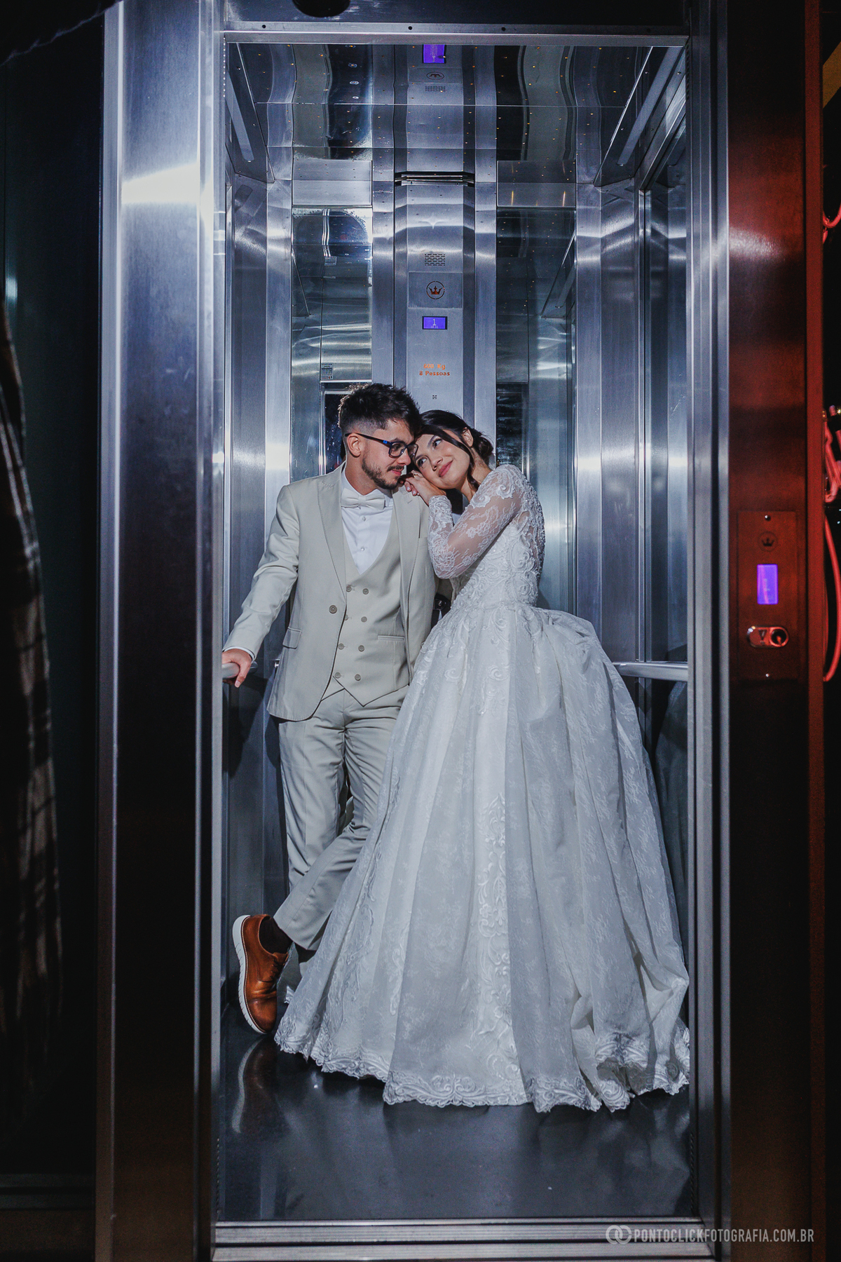 O casal registra um retrato criativo no elevador da recepção, criando uma fotografia moderna e cheia de personalidade para o casamento. Fotógrafo de casamento Pontoclick Fotografia.