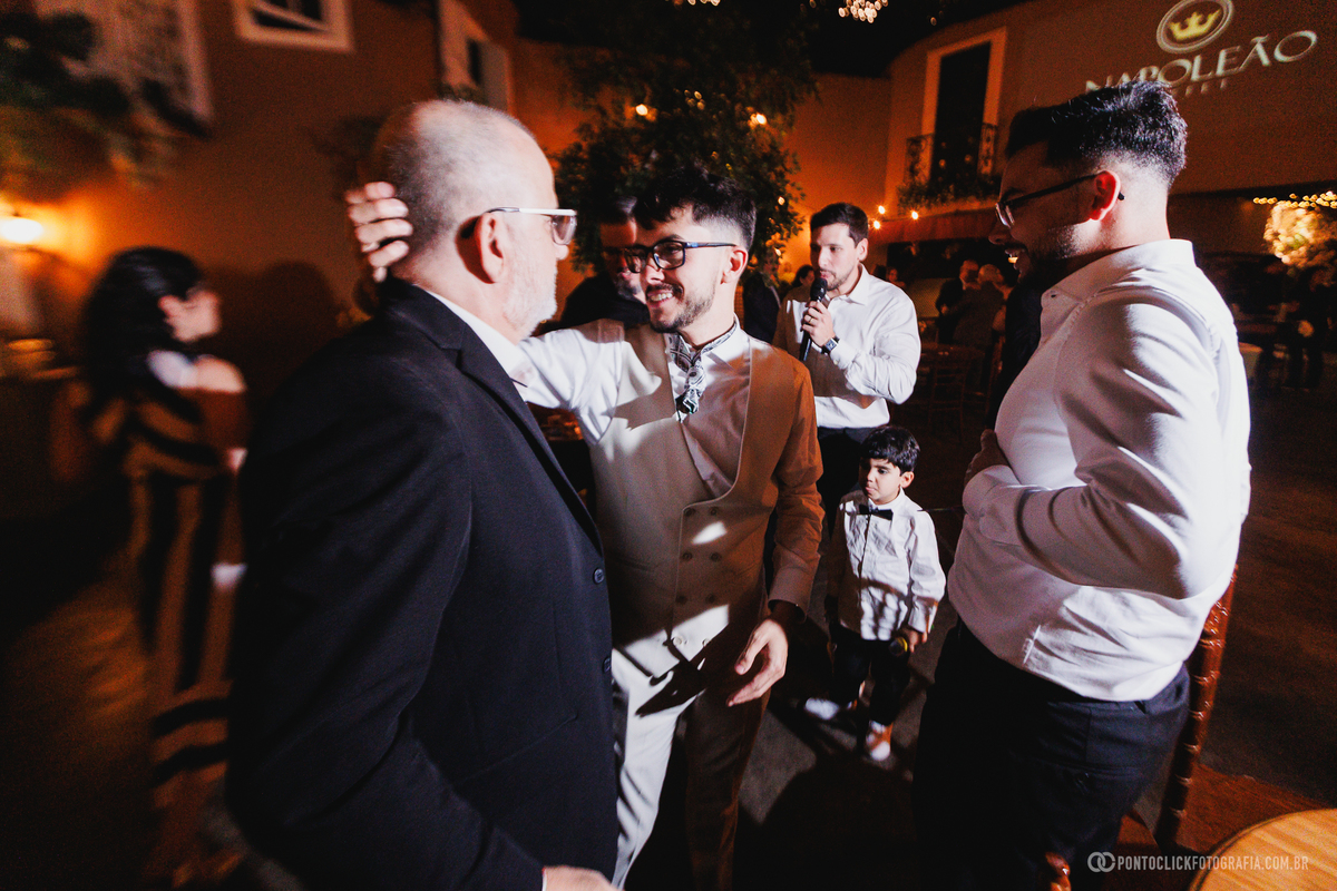 O noivo abraça um familiar durante a festa, compartilhando um momento de gratidão e felicidade ao lado das pessoas mais importantes da sua vida. Fotógrafo de casamento Pontoclick Fotografia.