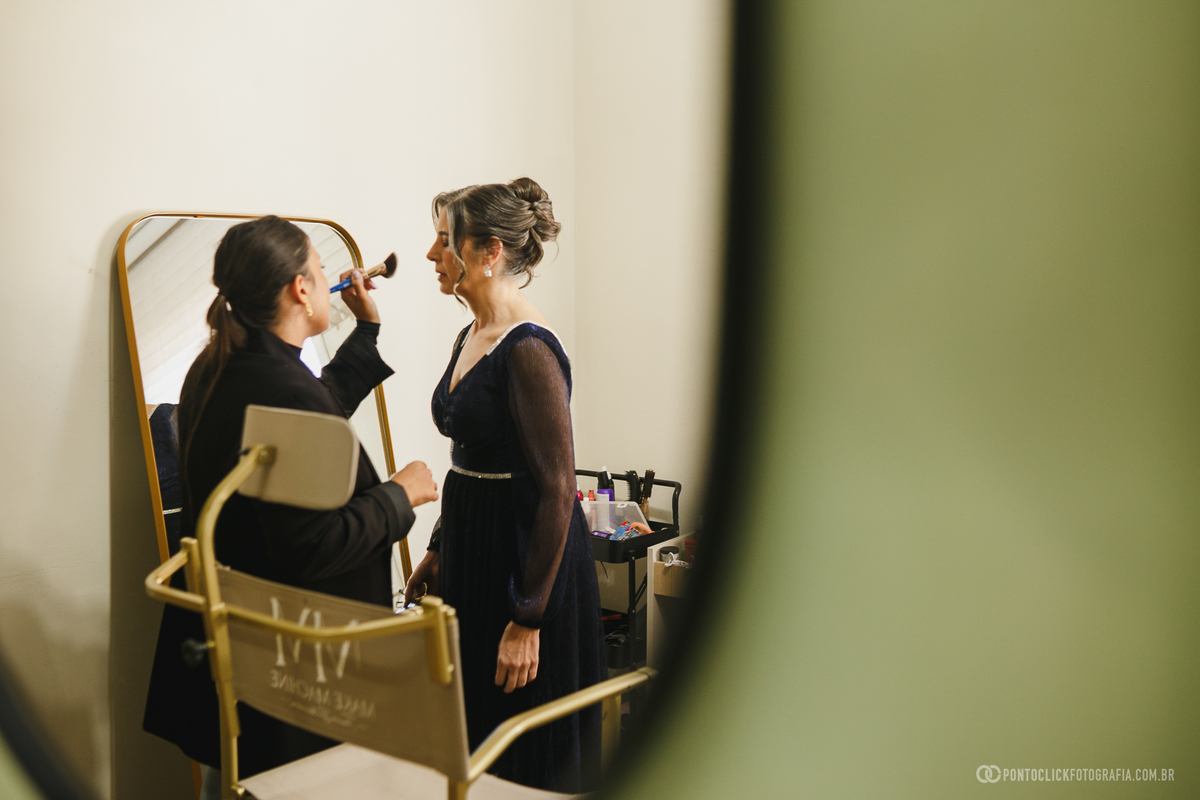 A mãe da noiva recebe os últimos retoques na maquiagem antes da cerimônia, registrando também a preparação das pessoas mais importantes desse grande dia. Fotógrafo de casamento Pontoclick Fotografia