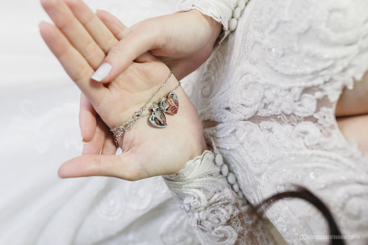 A noiva segura um relicário com fotos de familiares, carregando consigo uma lembrança especial para o dia do casamento. Fotógrafo de casamento Pontoclick Fotografia.
