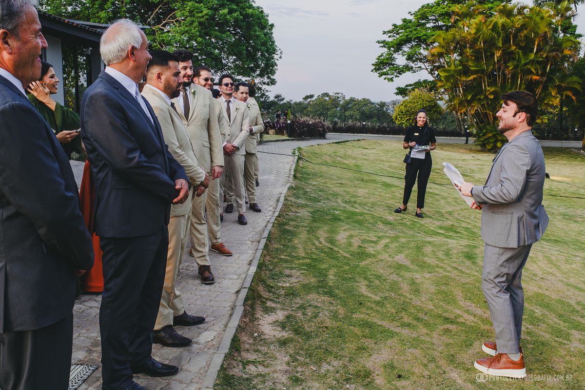 Homens de terno ouvem orientações no jardim antes da cerimônia de casamento. Fotógrafo de casamento Pontoclick Fotografia