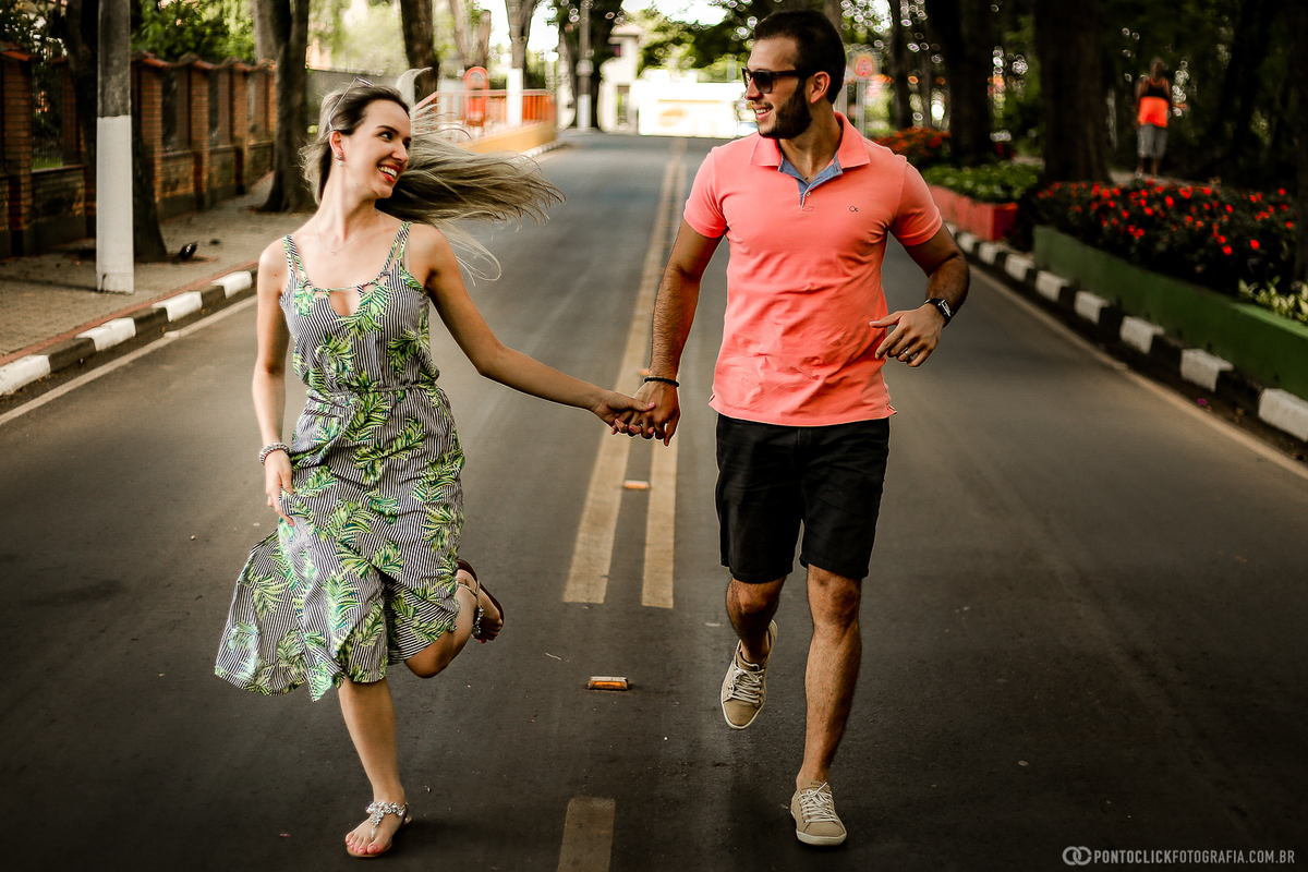casal correndo de maos dadas no meio da rua em holambra