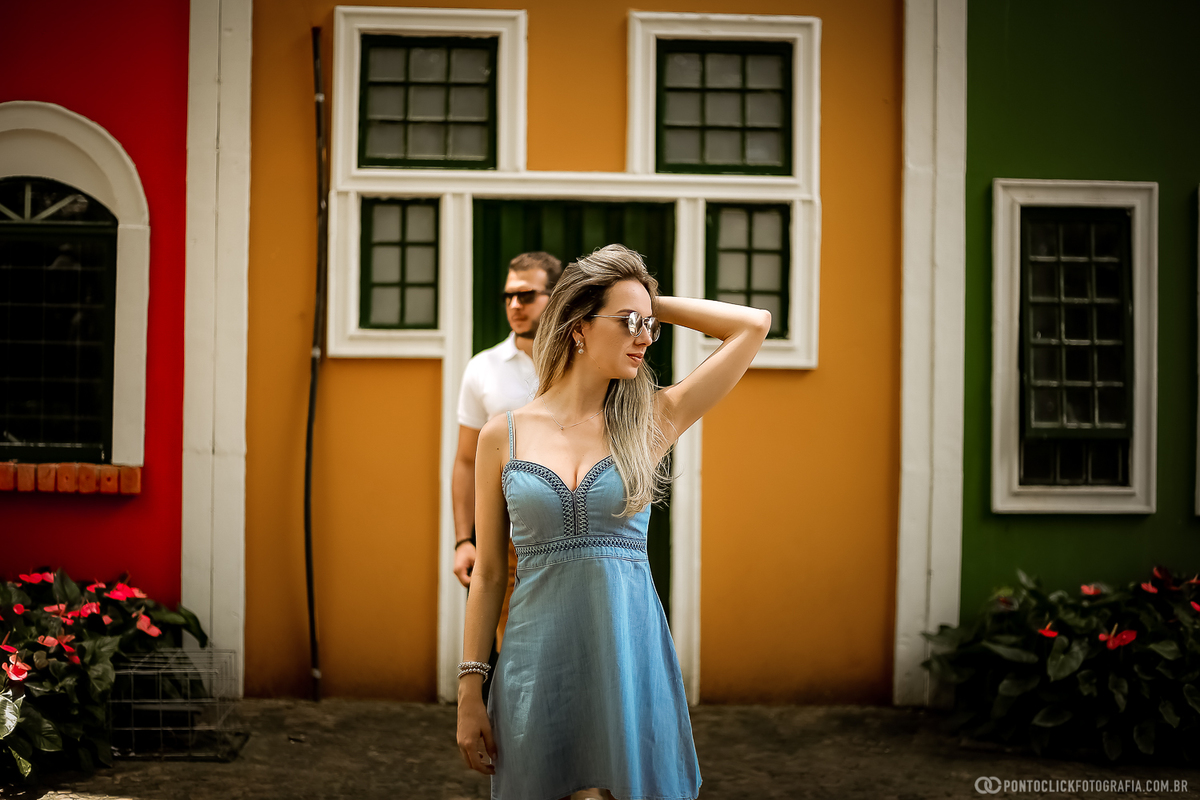 noiva mexendo no cabelo na frente do noivo e ao fundo um mural colorido em holambra