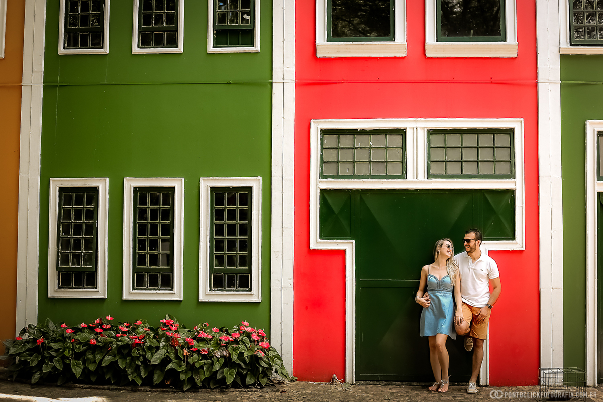 casal encostado e se olhando no mural colorido em holambra