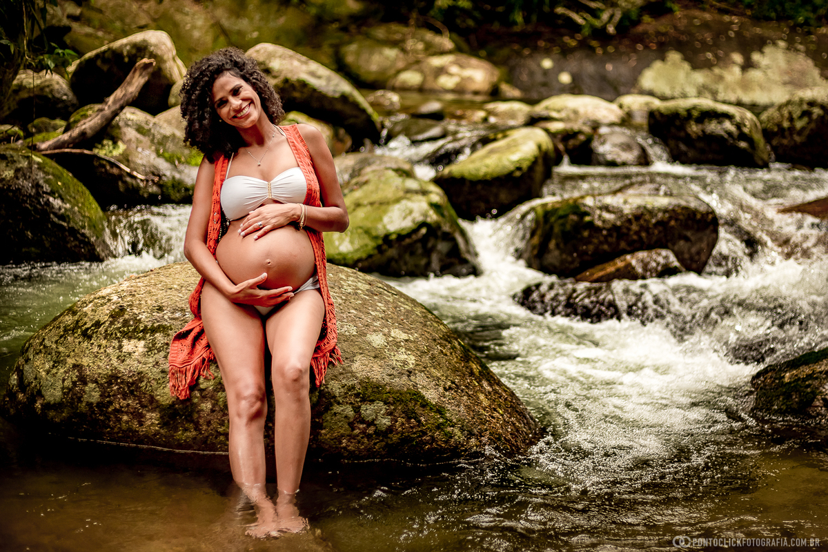 mamae gestante na cachoeira de ilhabela segurando a barriga