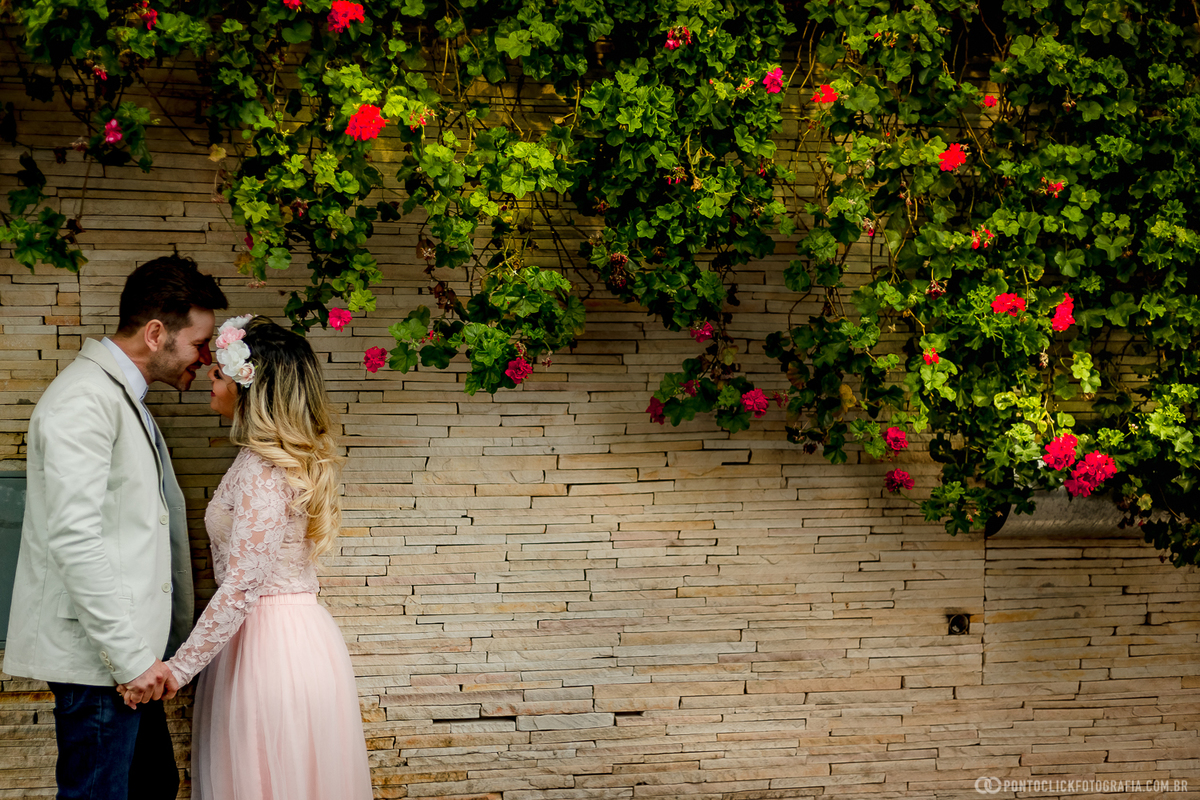 noivos se beijando e com um fundo florido