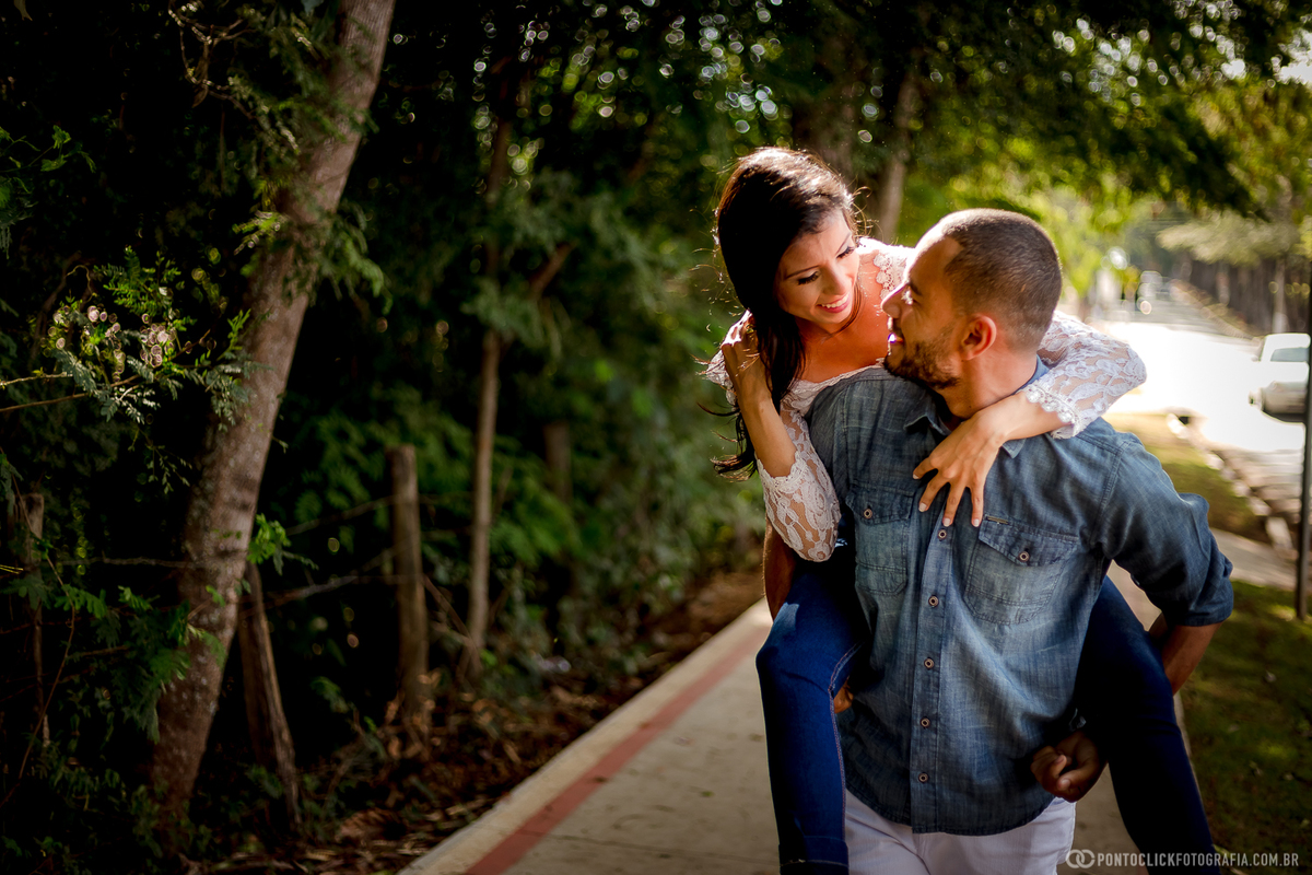 casal correndo e sorrindo noiva pulando nas costas do noivo em holambra