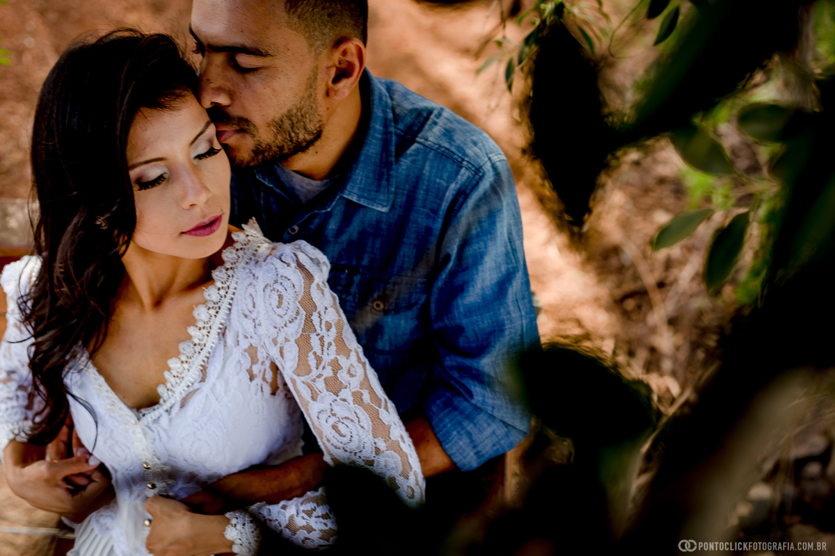 noivos abraçados e noivo beijando a noiva no deck do amor em holambra