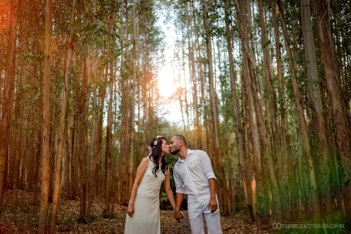 casal de noivos de mais dadas no meio de arvores simétricas em 