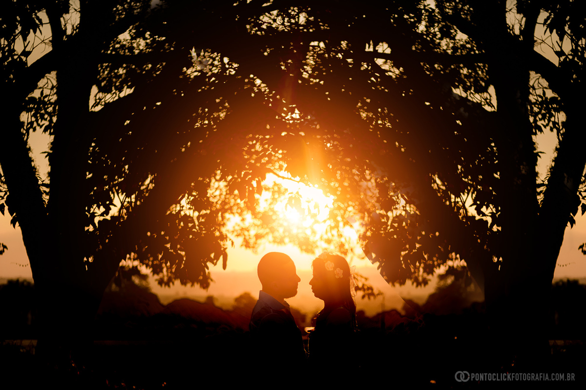 um lindo por do sol em holambra com um casal se olhando 