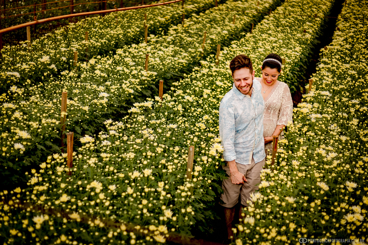 casal correndo no meio da plantação de flores em holmabra cidade das flores