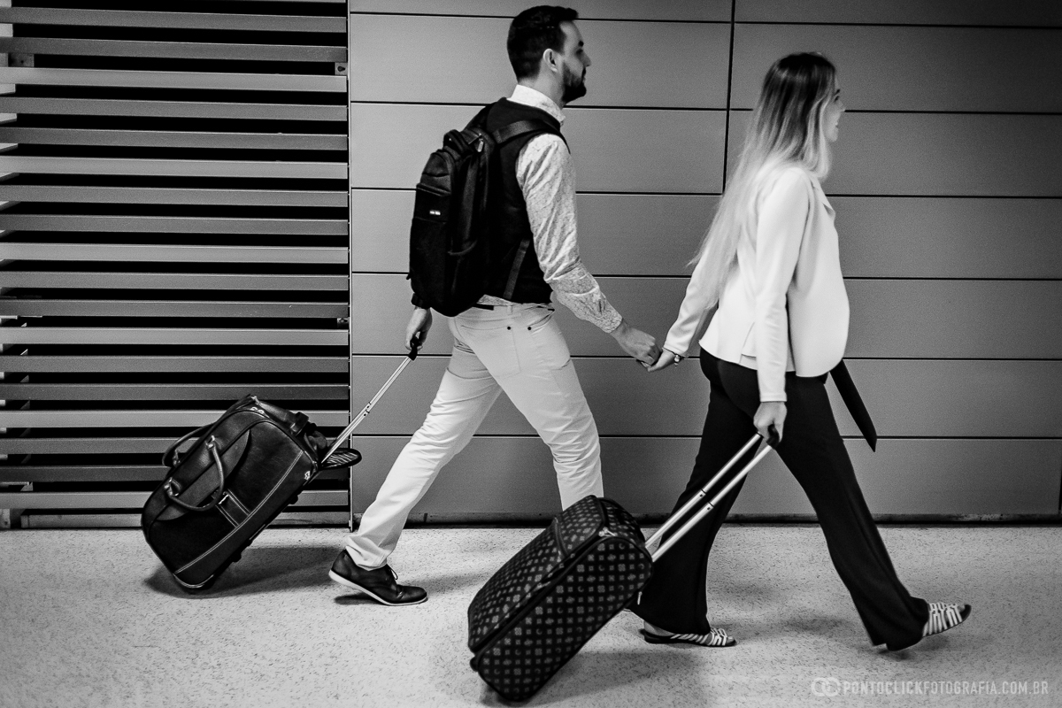casal caminhando de maos dadas em ensaio fotografico no aeroporto