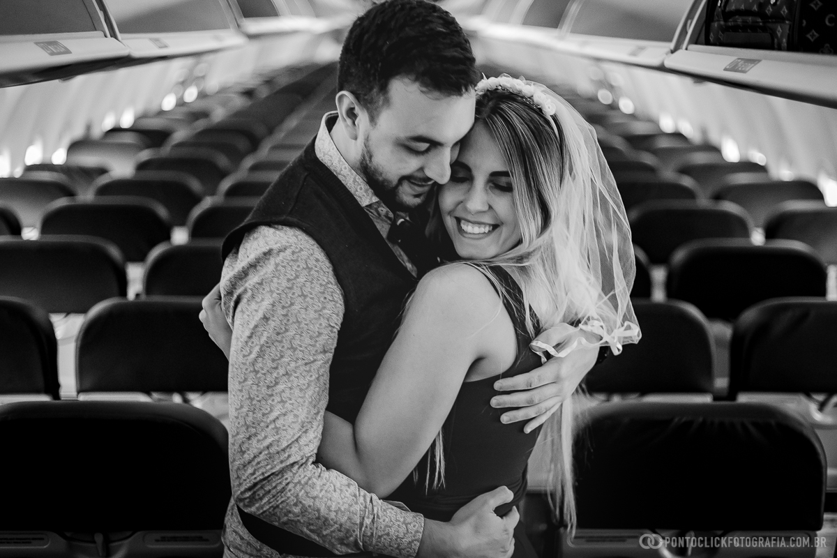 casal abraçados e noiva sorrindo dentro do aviao da gol no aeroporto de viracopos em campinas em ensaio fotografico no aeroporto